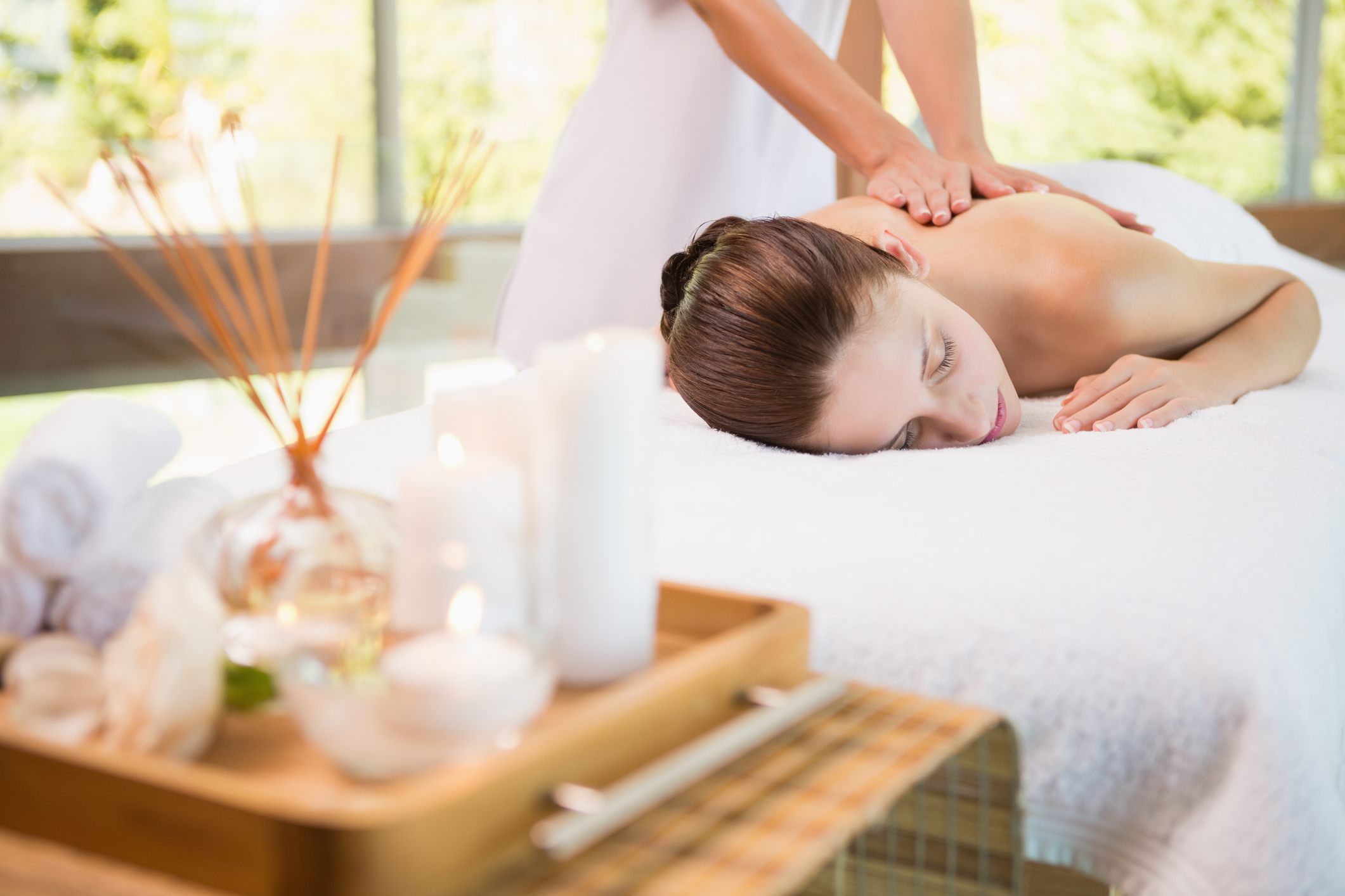 View of an attractive young woman receiving back massage at spa center
