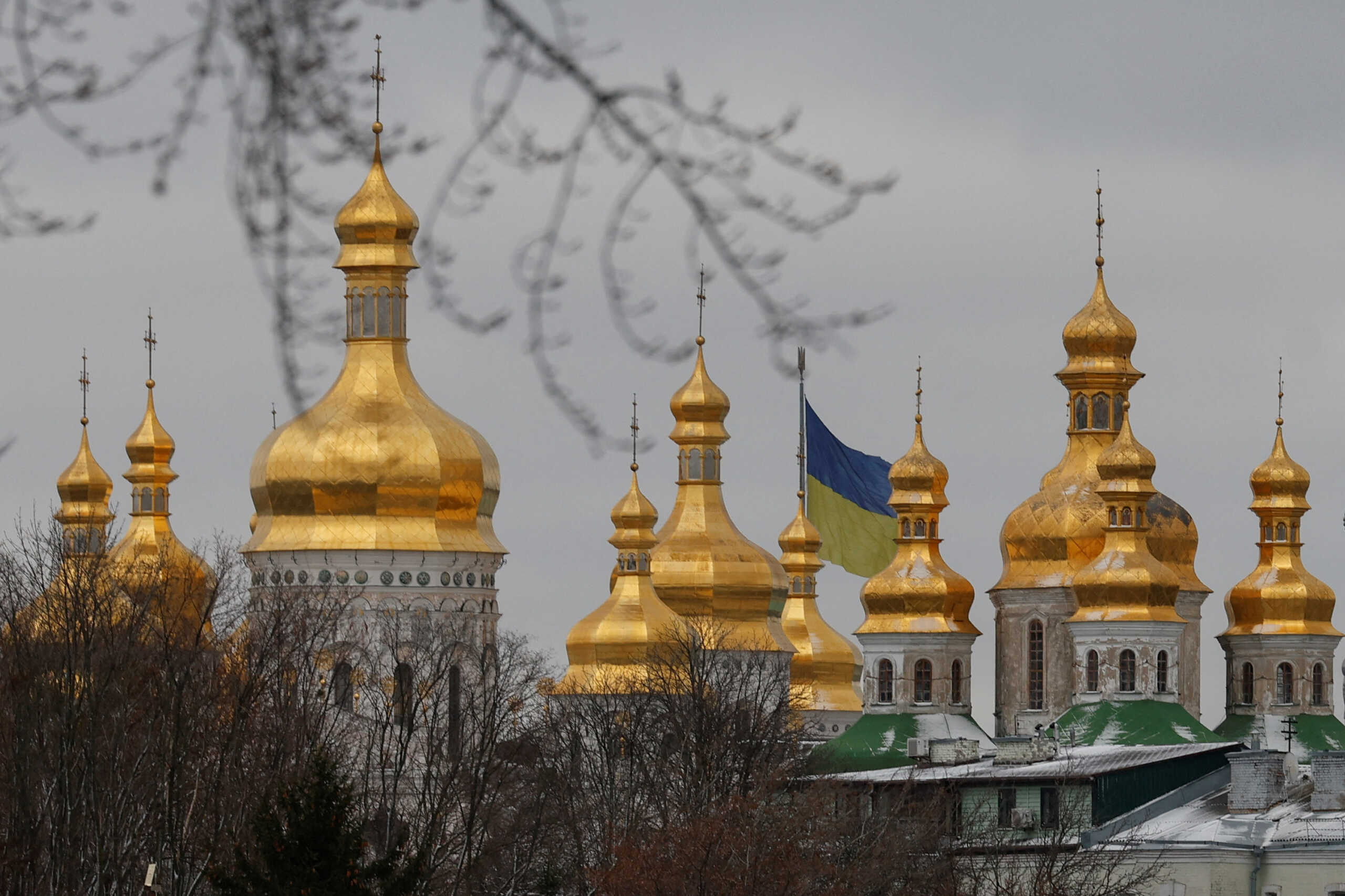 A Ukrainian national flag waves behind domes of the Uspenskyi (Holy Dormition) Cathedral at a compound of the Kyiv Pechersk Lavra monastery, amid Russia's attack on Ukraine, in Kyiv, Ukraine January 6, 2023. REUTERS