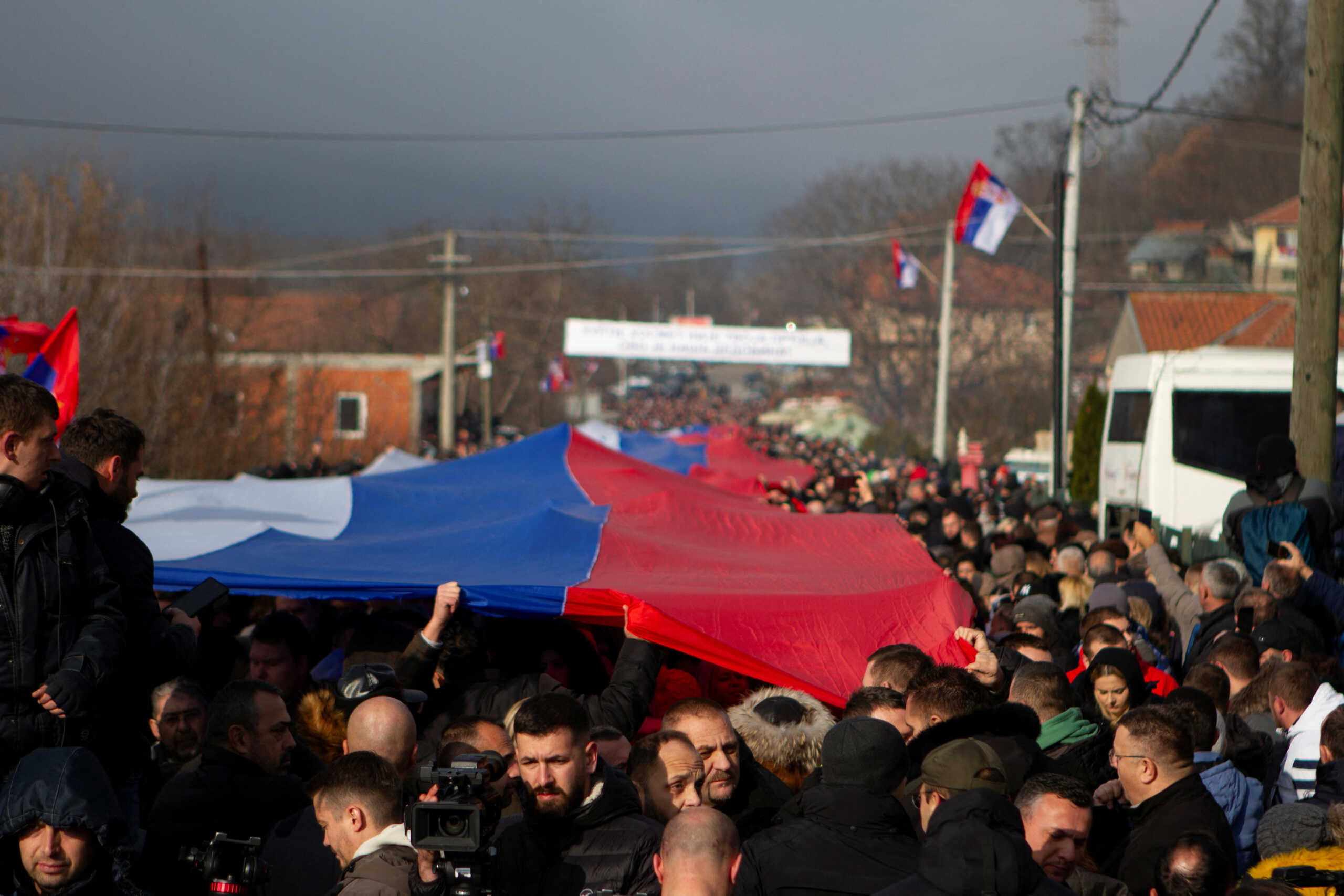 Local Serbs carry a giant Serbian flag as they protest against the government near a roadblock in Rudare, near the northern part of the ethnically-divided town of Mitrovica, Kosovo, December 22, 2022. REUTERS