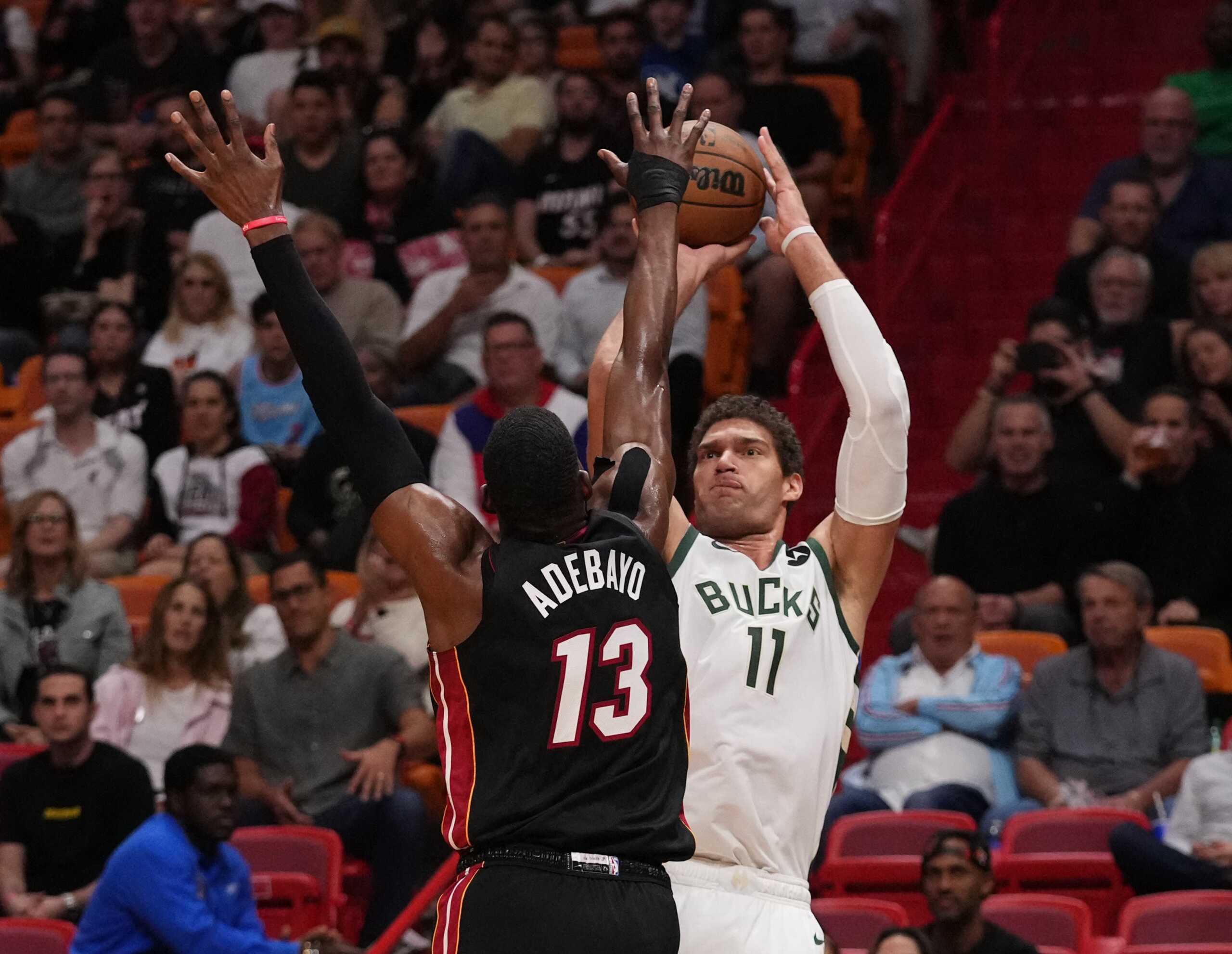 Jan 12, 2023; Miami, Florida, USA; Milwaukee Bucks center Brook Lopez (11) shoots over Miami Heat center Bam Adebayo (13) at The Arena. Mandatory Credit: Jasen Vinlove-USA TODAY Sports