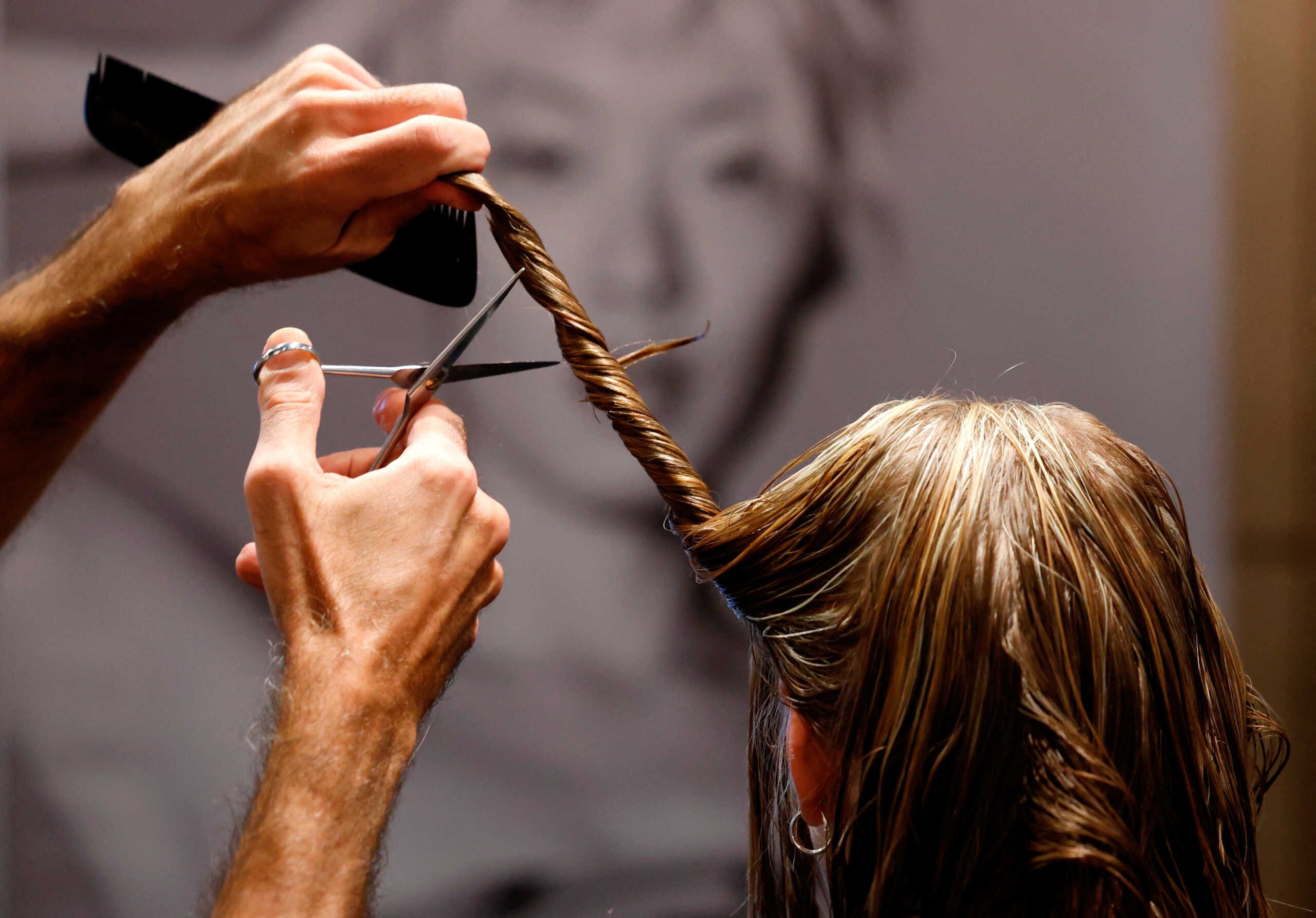 Belgian hairdresser at hair salon L'Atelier Chedly Boussigua cuts a customer's hair, which will be collected by the association Dung Dung that transforms hair into tiles used to absorb polluting chemical substances in water, in Brussels, Belgium November 4, 2022. REUTERS