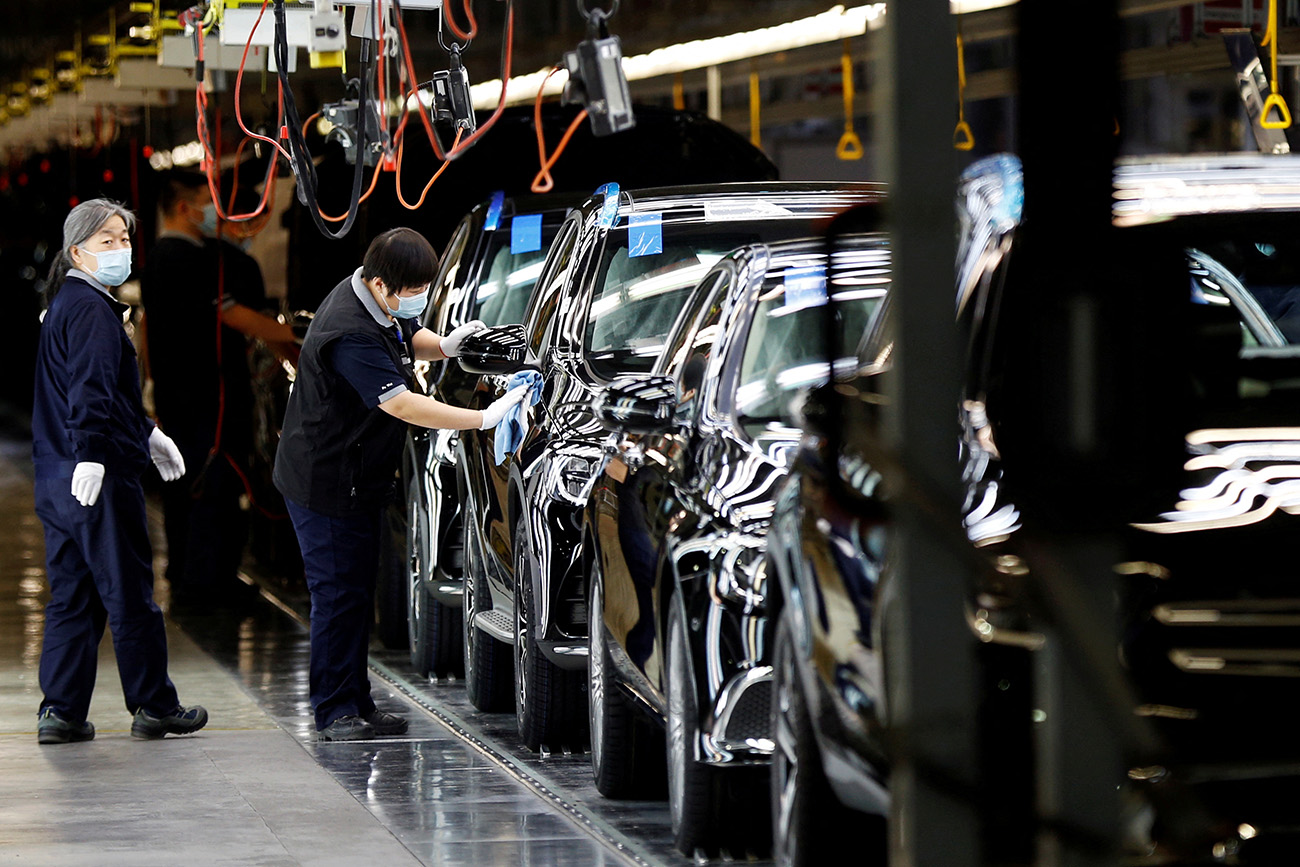 FILE PHOTO: Employees work on the production line during an organised media tour to a factory of Beijing Benz Automotive Co (BBAC), a joint venture by BAIC Motor and Mercedes-Benz, in Beijing, China February 17, 2022. REUTERS