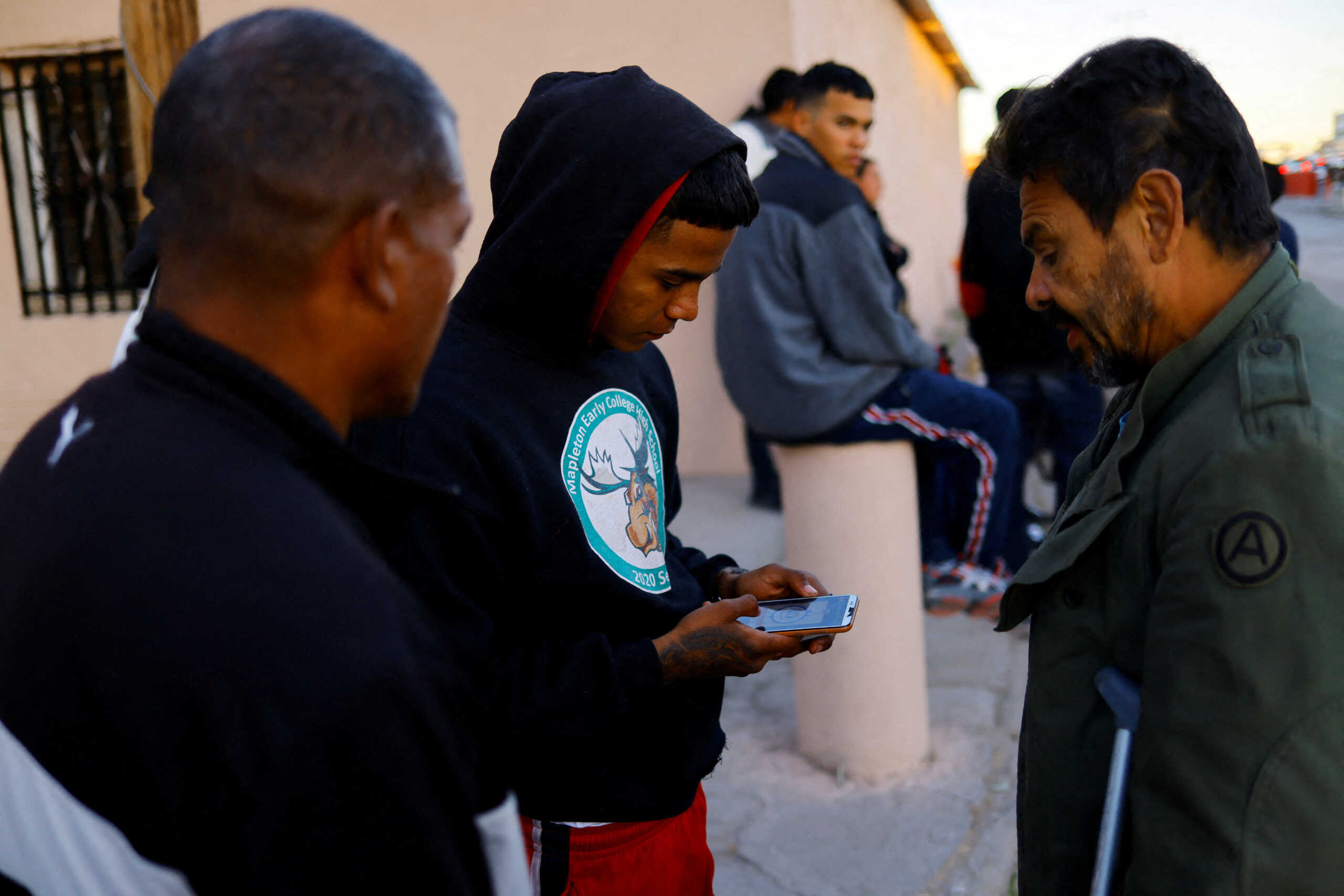FILE PHOTO: Migrants seeking asylum in the U.S. use their phones to access the U.S. Customs and Border Protection (CBP) CBP ONE application to request an appointment at a land port of entry to the U.S., outside a shelter in Ciudad Juarez, Mexico January 12, 2023. REUTERS