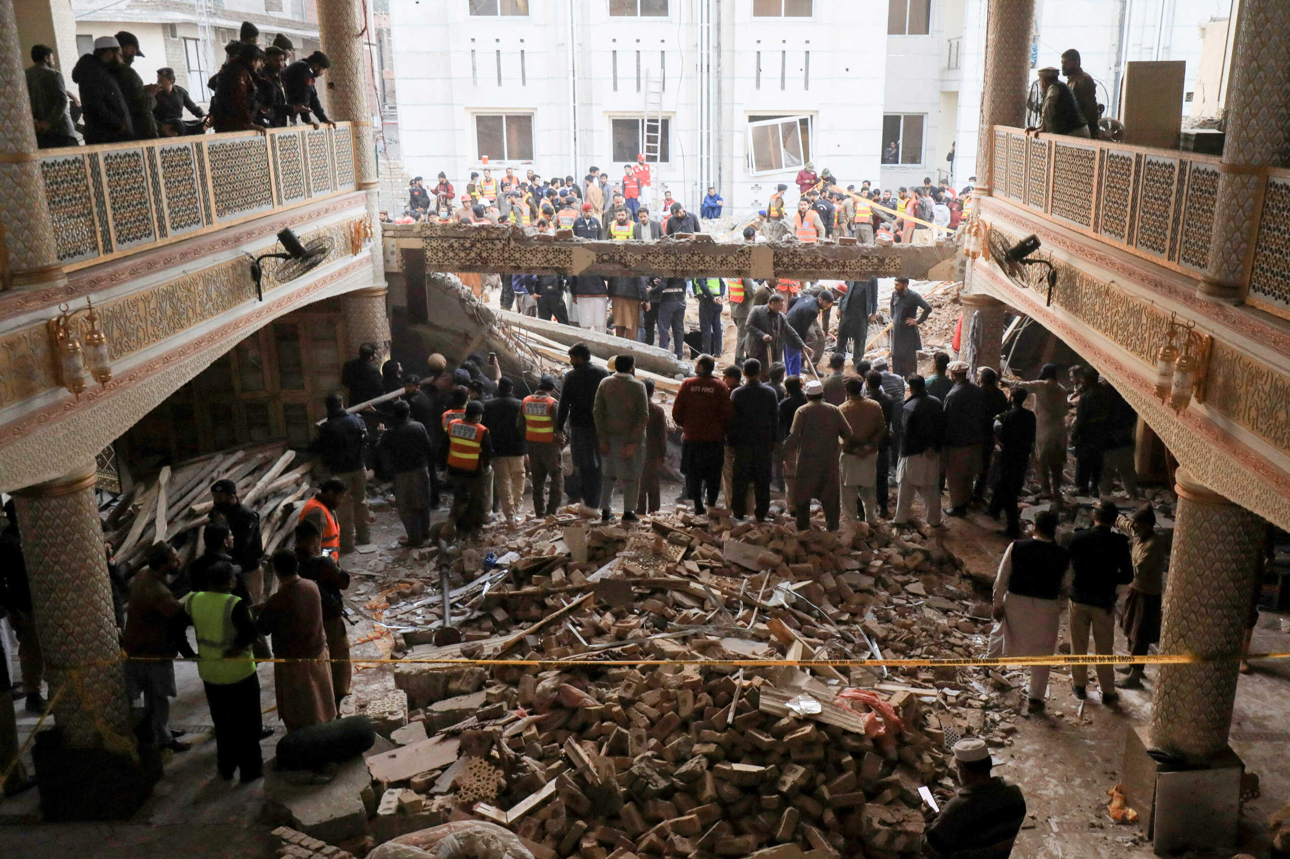 People and rescue workers gather to look for survivors under a collapsed roof, after a suicide blast in a mosque in Peshawar, Pakistan January 30, 2023. REUTERS