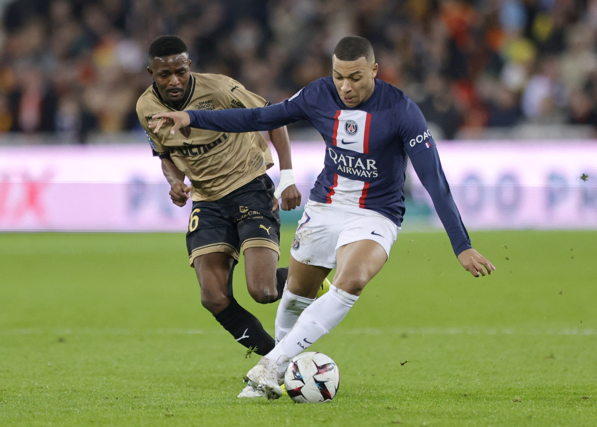 Soccer Football - Ligue 1 - RC Lens v Paris St Germain - Stade Bollaert-Delelis, Lens, France - January 1, 2023 Paris St Germain's Kylian Mbappe in action with RC Lens' Salis Abdul Samed REUTERS
