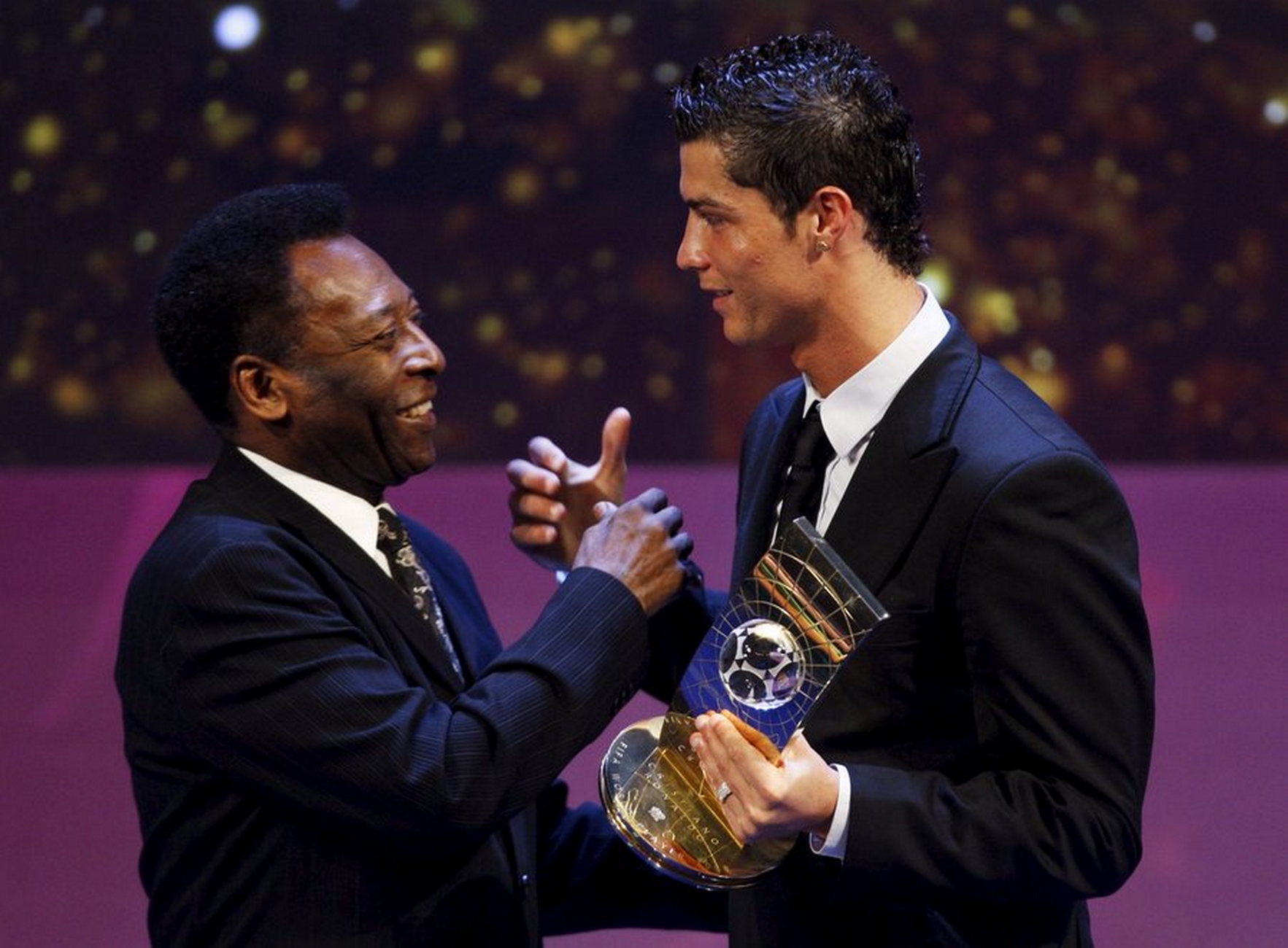 epa01598016 Soccer player Cristiano Ronaldo from Portugal, (R), receives the trophy from former Brazilian soccer star Pele after being named FIFA World Player of the Year during the FIFA World Player Gala 2008 at the Opera house in Zurich, Switzerland, 12 January 2009.  EPA