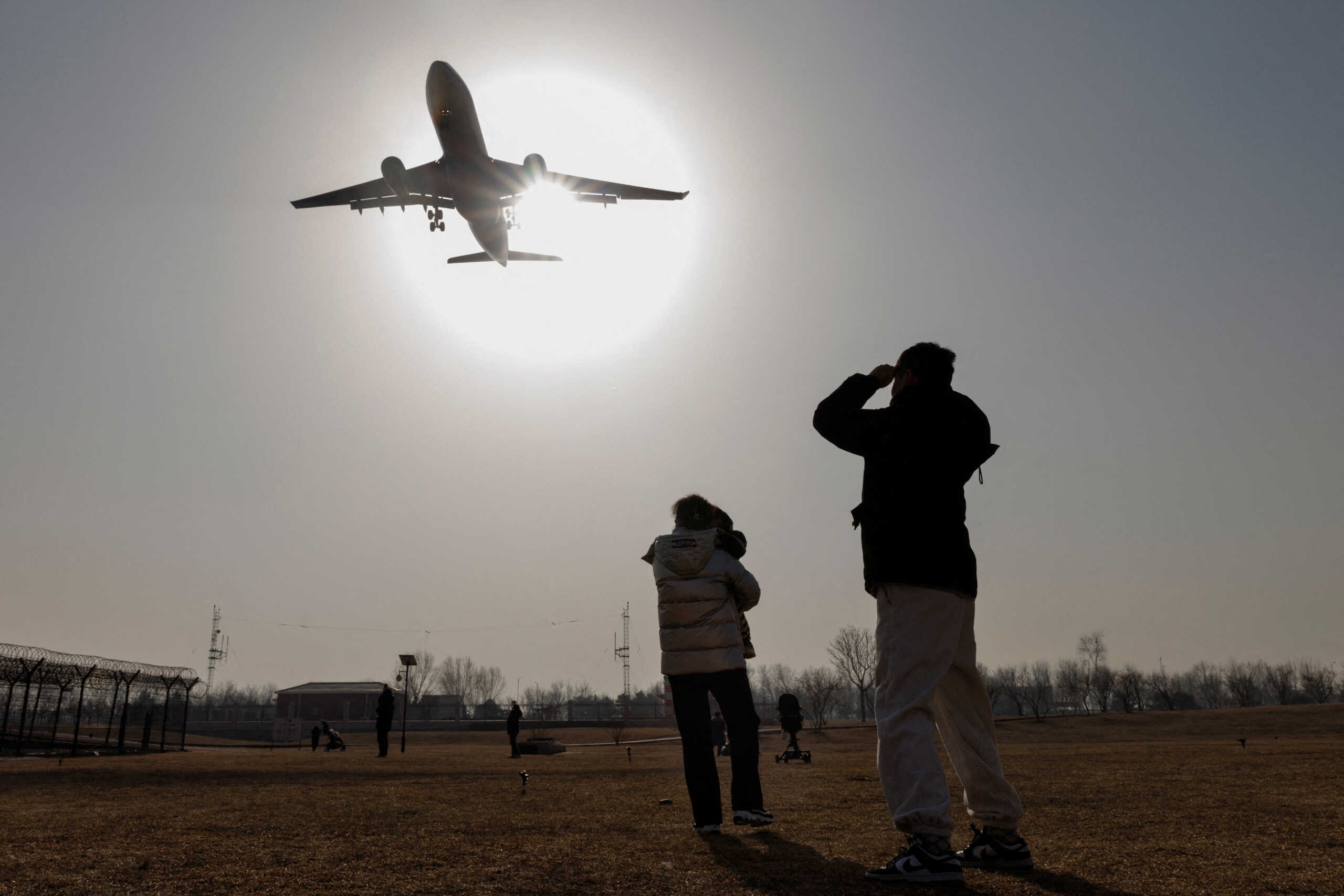 People watch a plane land at Beijing Capital International Airport as coronavirus disease (COVID-19) outbreaks continue in Beijing, China January 6, 2023. REUTERS