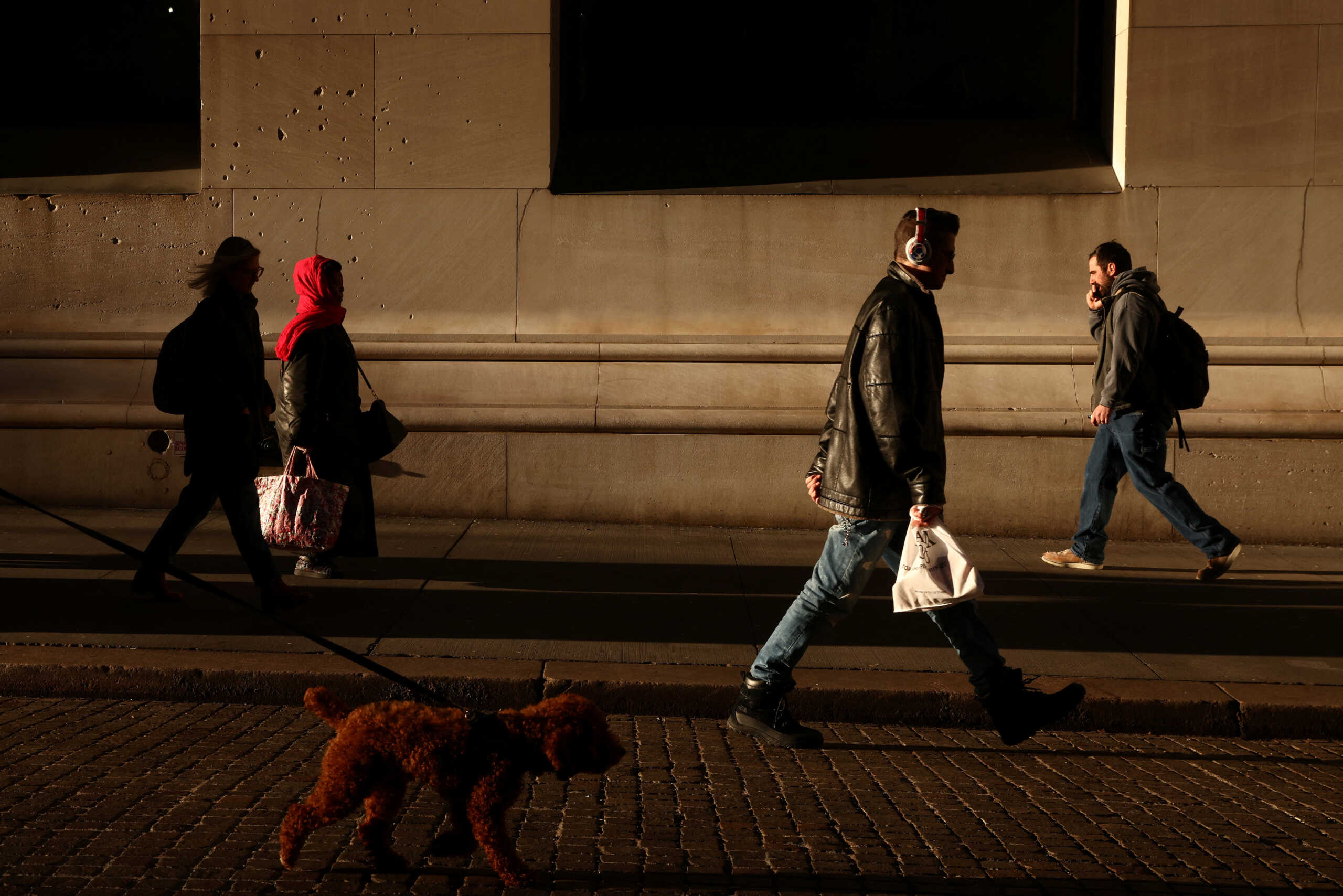 People walk along Wall Street in New York City, U.S., January 27, 2023. REUTERS