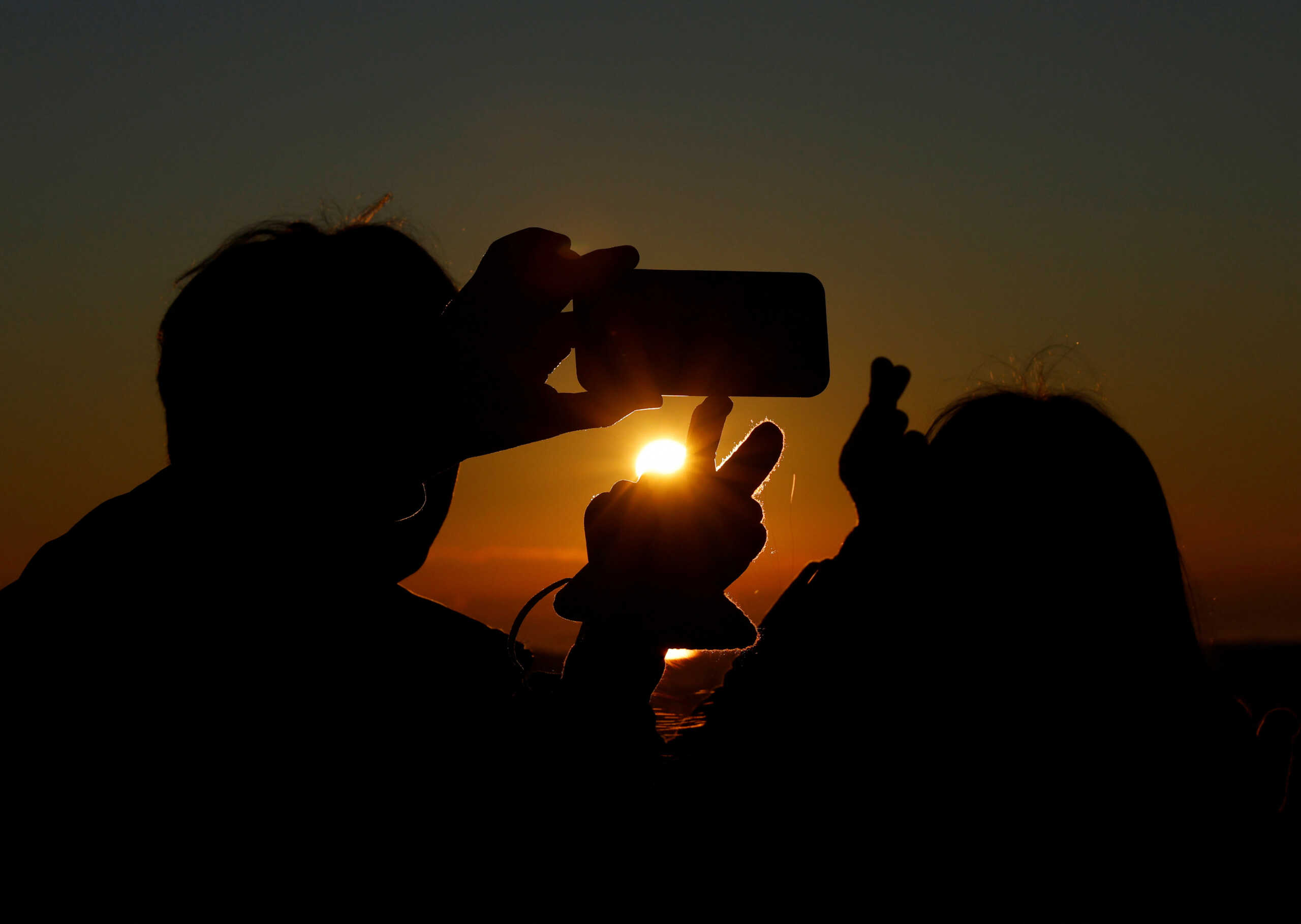 Visitors take their selfies with the first sun rise of the year at the Shibuya Sky observation deck in Tokyo, Japan, January 1, 2023. REUTERS