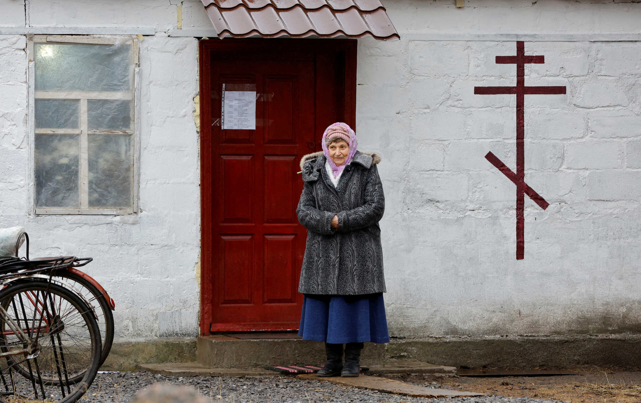 Local resident Vera Barda, 74, stands outside a chapel located in her granddaughter's house during the Orthodox Christmas Eve service in the town of Volnovakha in the Donetsk region, Russian-controlled Ukraine, January 6, 2023. REUTERS
