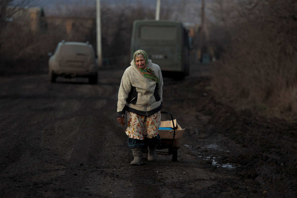 Local resident Mariia, 78, carries a cart with a humanitarian aid, amid Russia's attack on Ukraine, in the village of Nykyforivka, Donetsk region, Ukraine January 21, 2023. REUTERS