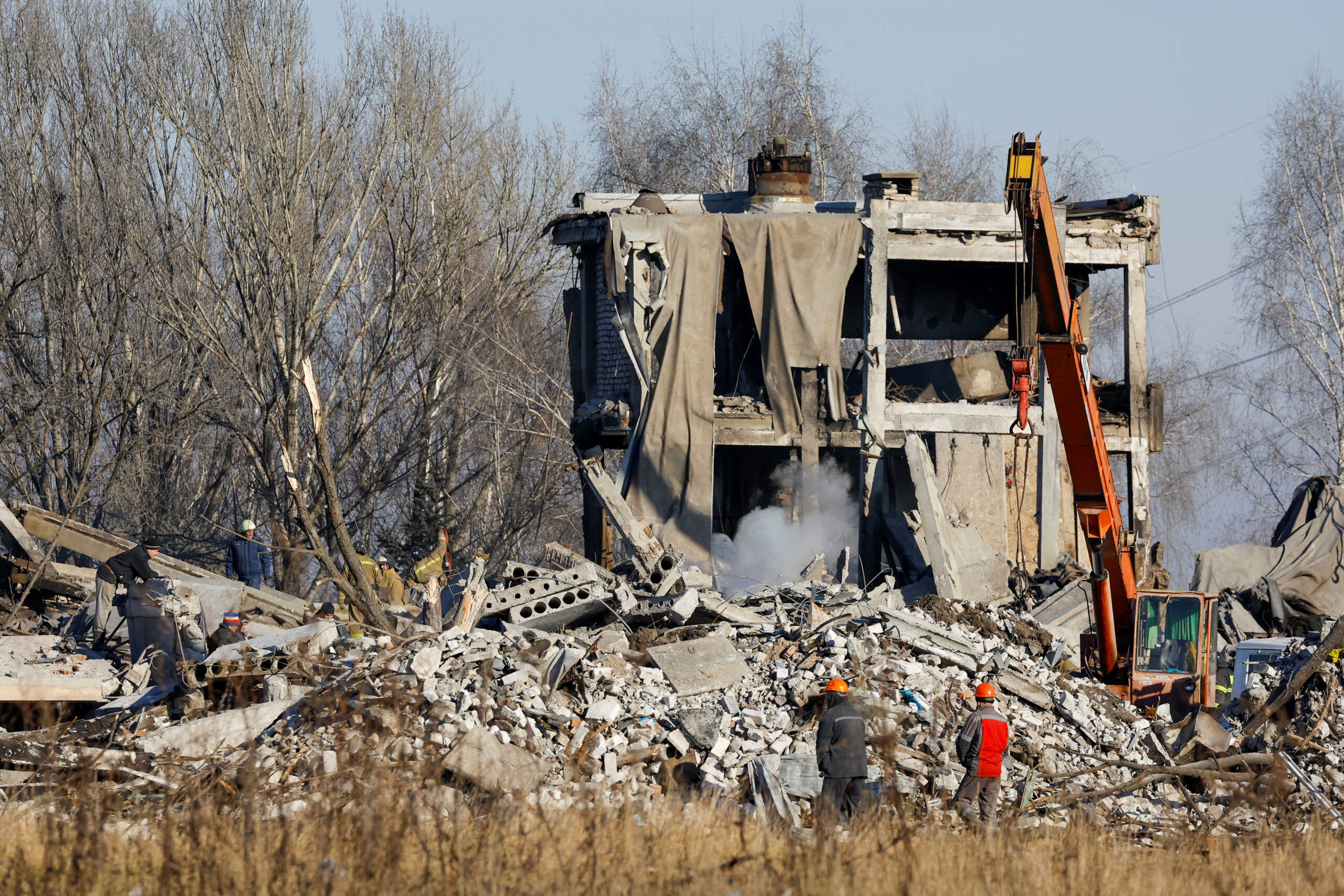 Workers remove debris of a destroyed building purported to be a vocational college used as temporary accommodation for Russian soldiers, 63 of whom were killed in a Ukrainian missile strike as stated the previous day by Russia's Defence Ministry, in the course of Russia-Ukraine conflict in Makiivka (Makeyevka), Russian-controlled Ukraine, January 3, 2023. REUTERS