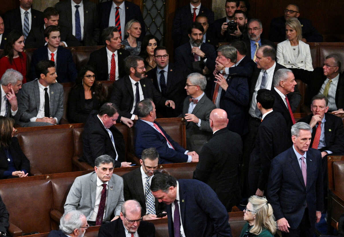 A member of the House of Representatives grabs Rep. Mike Rogers (R-AL) by the face as House Republican Leader Kevin McCarthy walks away after Rogers approached Rep. Matt Gaetz (R-FL) and members of the House Freedom Caucus after Gaetz voted "present" rather than voting for McCarthy in a late night 14th round of voting for a new House Speaker on the fourth day of the 118th Congress at the U.S. Capitol in Washington, U.S., January 6, 2023. REUTERS