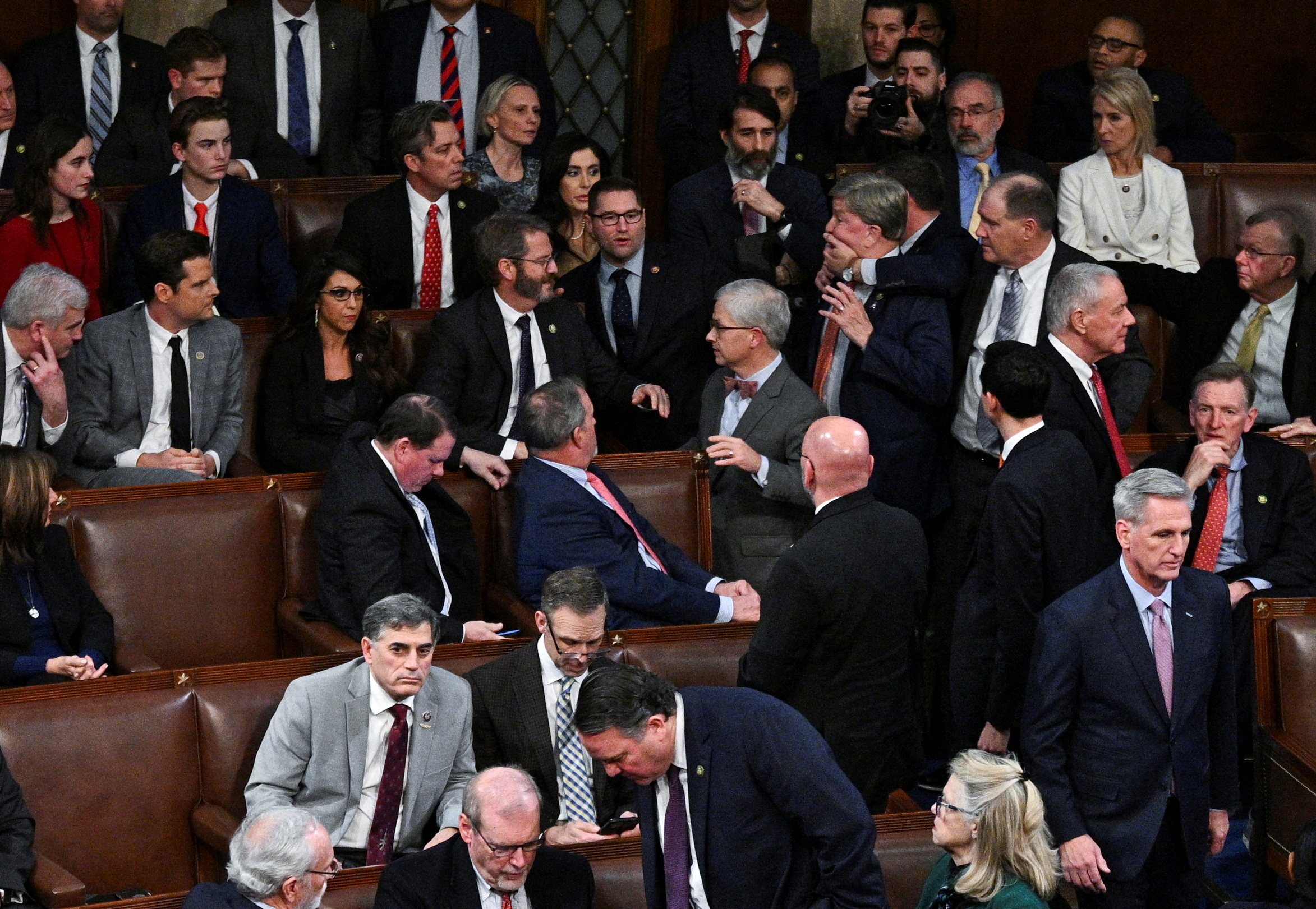 A member of the House of Representatives grabs Rep. Mike Rogers (R-AL) by the face as House Republican Leader Kevin McCarthy walks away after Rogers approached Rep. Matt Gaetz (R-FL) and members of the House Freedom Caucus after Gaetz voted "present" rather than voting for McCarthy in a late night 14th round of voting for a new House Speaker on the fourth day of the 118th Congress at the U.S. Capitol in Washington, U.S., January 6, 2023. REUTERS