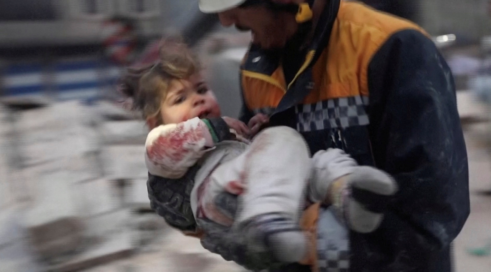 A rescuer carries an injured child away from the rubble of a building following an earthquake in rebel-held Azaz, Syria February 6, 2023 in this still image taken from video. REUTERS TV