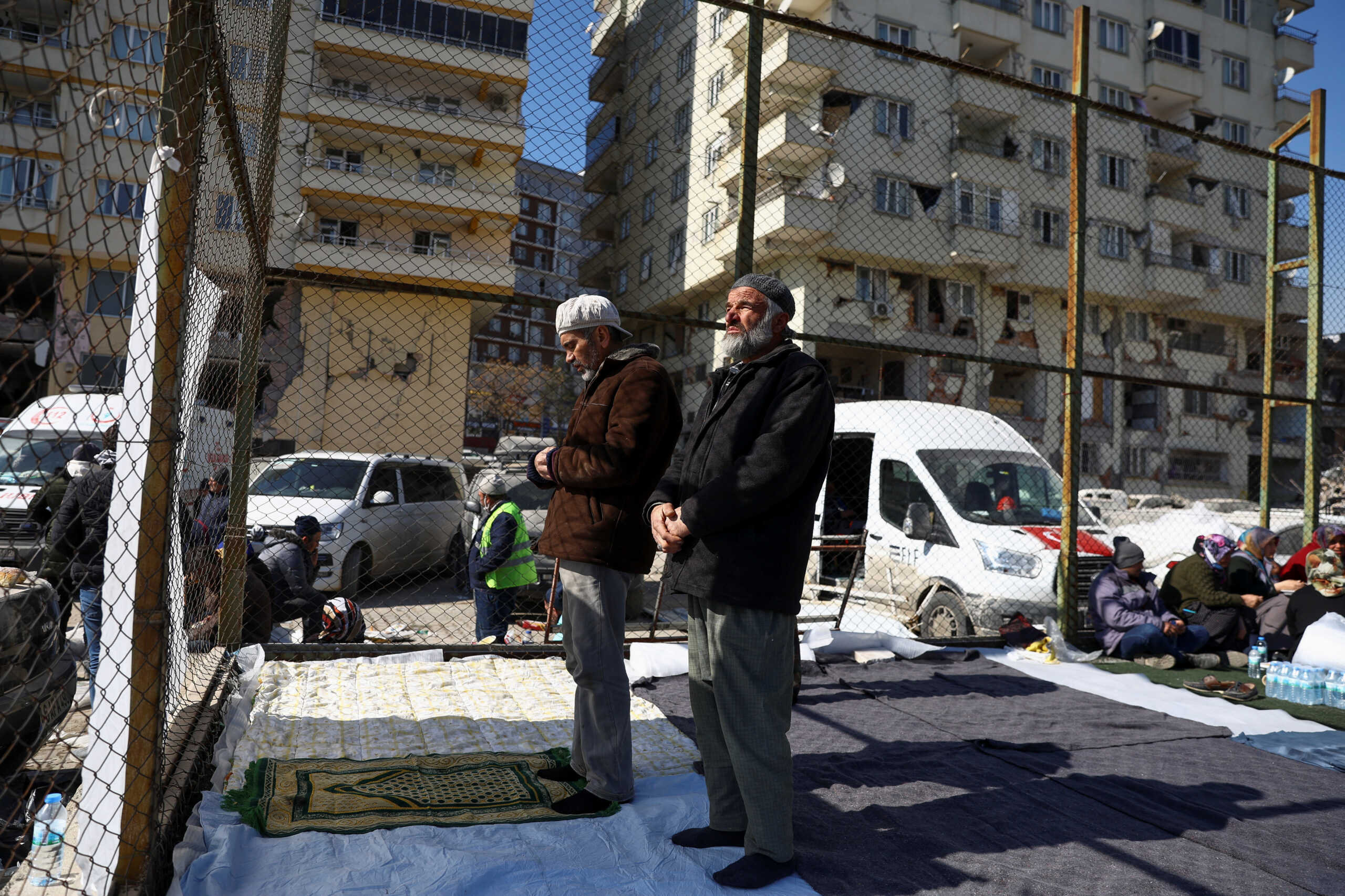 Turkish men pray near the site of a collapsed building in the aftermath of a deadly earthquake in Kahramanmaras, Turkey February 11, 2023. REUTERS