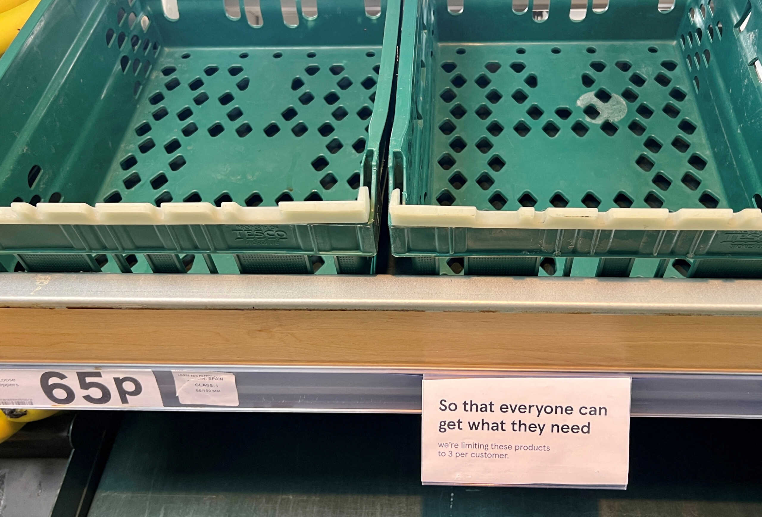 FILE PHOTO: A sign limiting customers to three items each is seen next to empty boxes in the tomato and peppers section of a Tesco supermarket, in Manchester, Britain, February 22, 2023. REUTERS