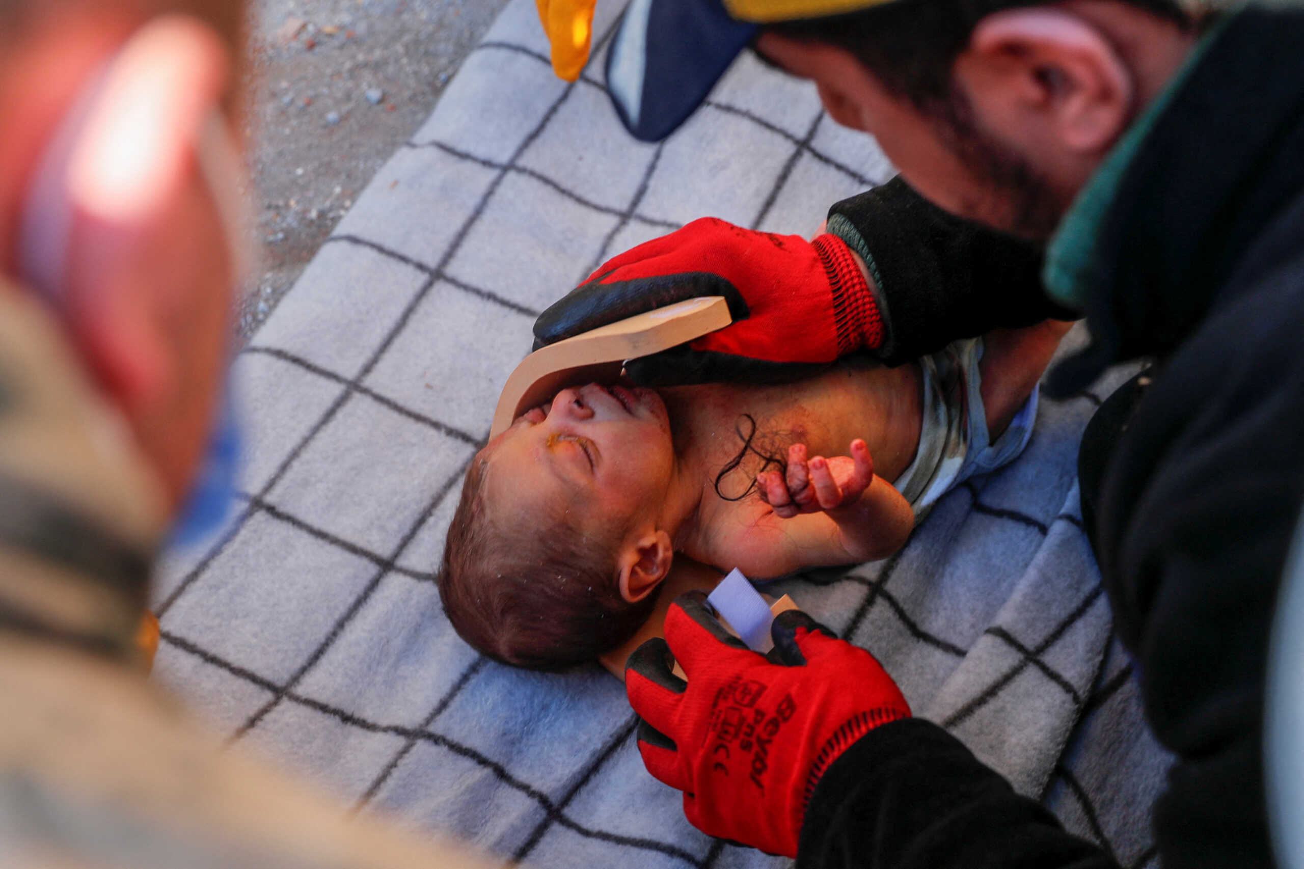 A rescuer cleans the face of baby boy Kerem Agirtas, a 20-day-old survivor who was pulled from under the rubble, in the aftermath of a deadly earthquake in Hatay, Turkey, February 8, 2023. REUTERS