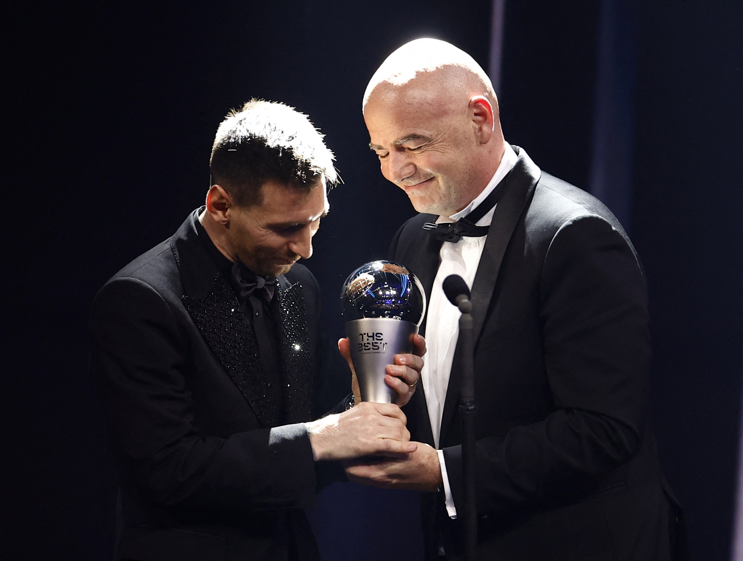Soccer Football - The Best FIFA Football Awards - Salle Pleyel, Paris, France - February 27, 2023 Paris St Germain's Lionel Messi winner of The Best FIFA Player award 2022 receives the trophy from FIFA president Gianni Infantino REUTERS