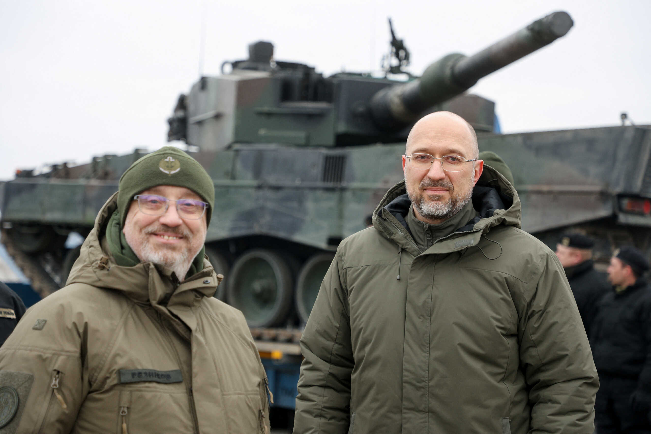 Ukrainian Prime Minister Denys Shmyhal and Defence Minister Oleksii Reznikov stand next to the first Leopard 2 tanks delivered from Poland on a day of the first anniversary of Russia's attack on Ukraine, in an undisclosed location, Ukraine February 24, 2023.  Ukrainian Governmental Press Service
