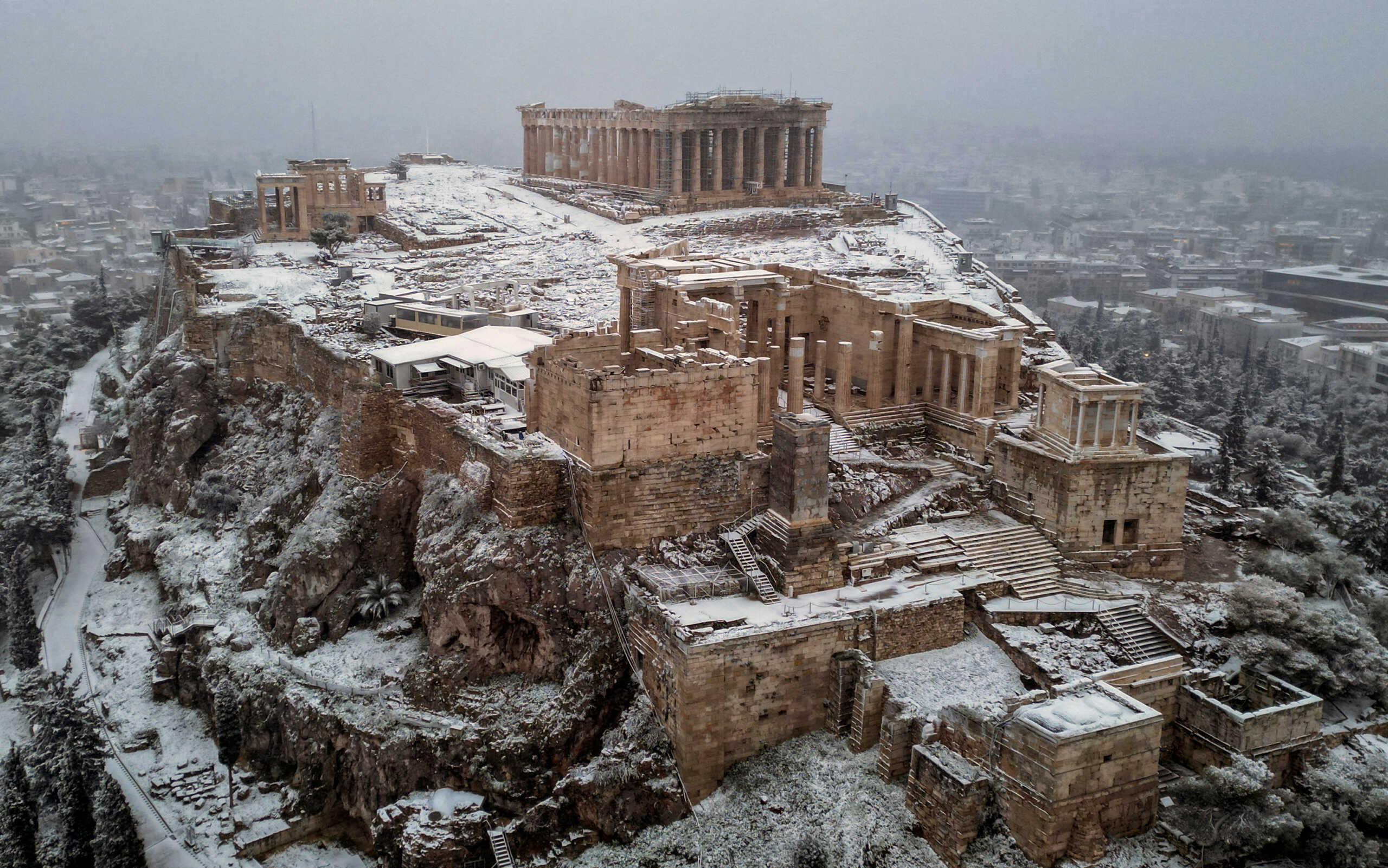 A view of the Parthenon temple atop the Acropolis hill, during snowfall in Athens, Greece, February 6, 2023. REUTERS