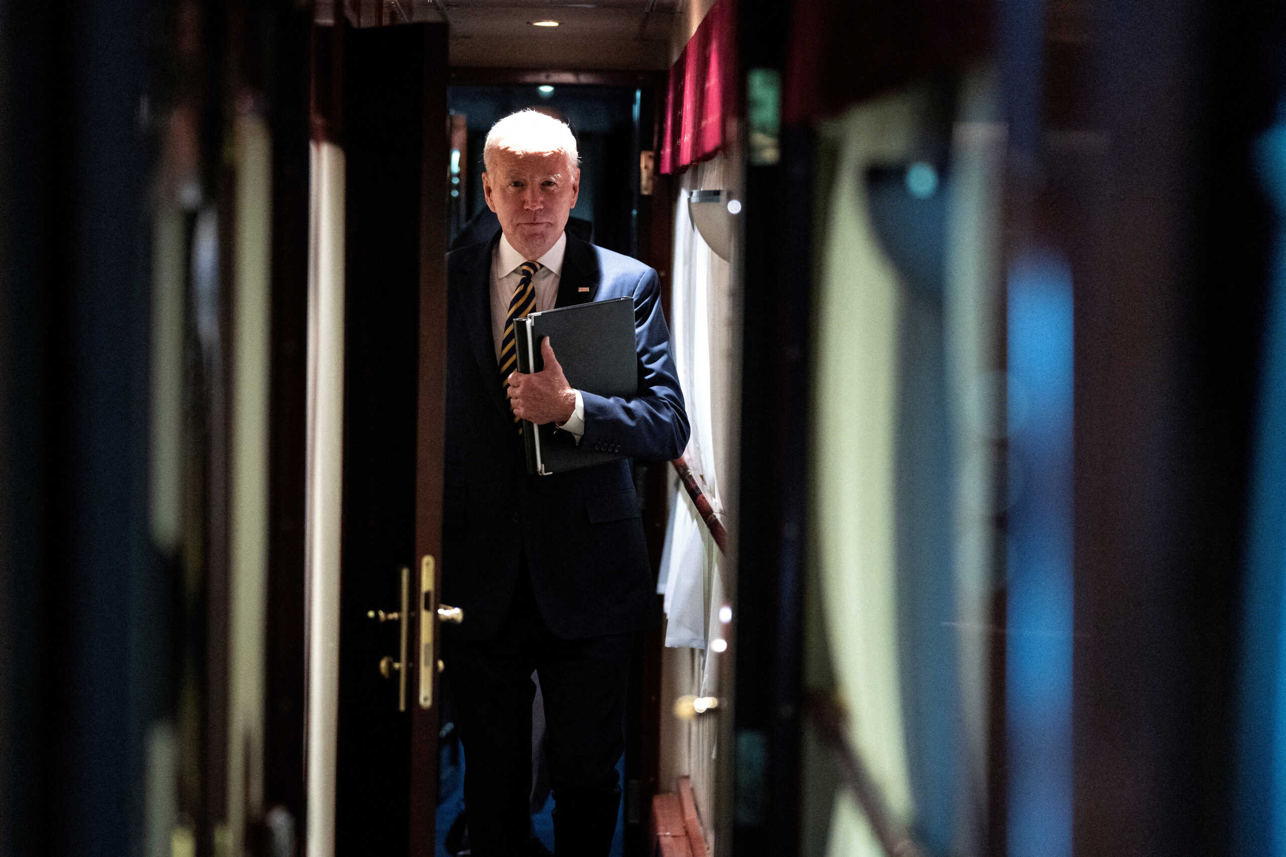 President Joe Biden walks down a corridor to his cabin on a train after a surprise visit with Ukrainian President Volodymyr Zelenskiy, Monday, Feb. 20, 2023, in Kyiv. Biden took a nearly 10-hour train ride from Poland into Kyiv. Evan Vucci