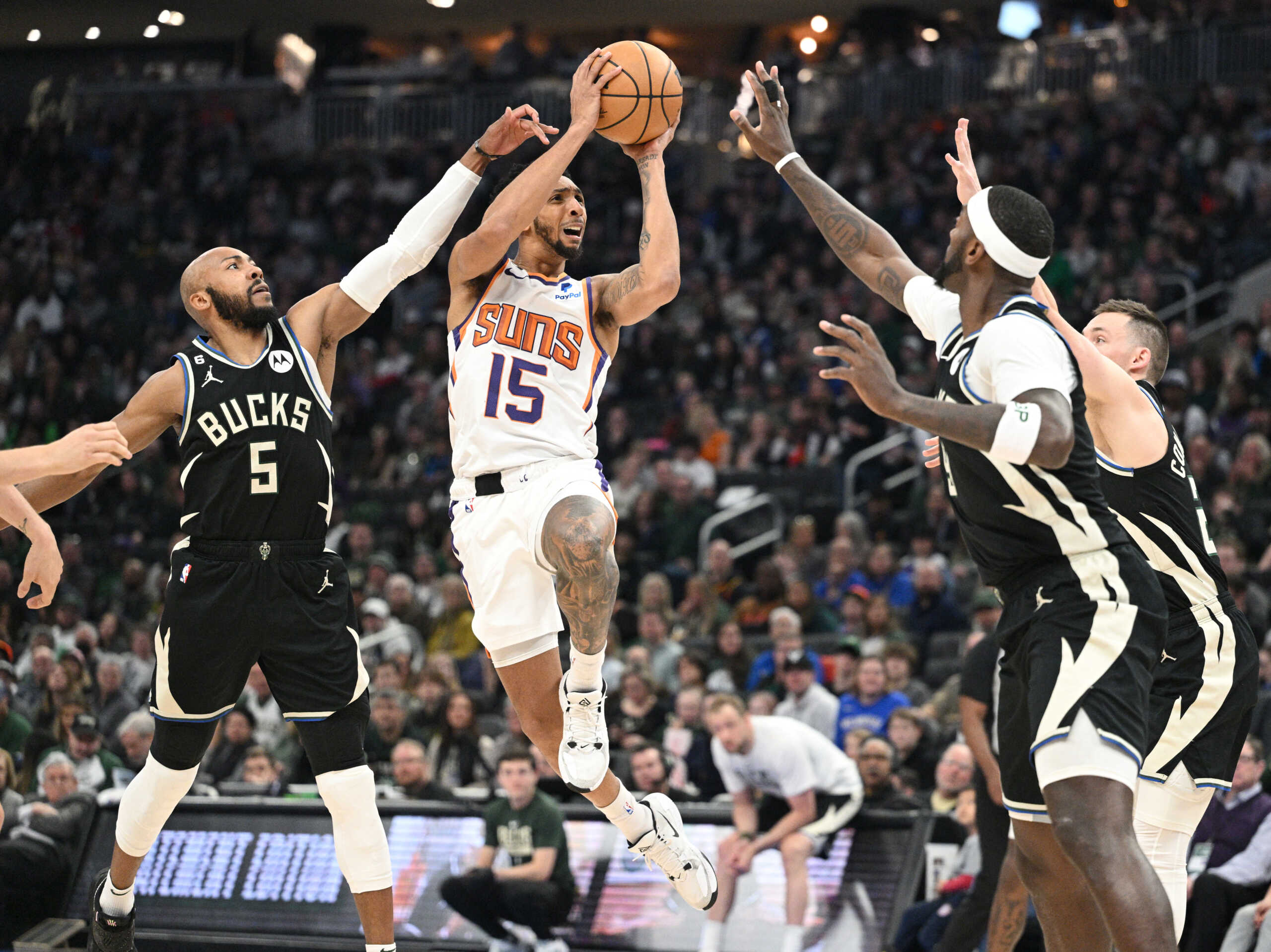 Feb 26, 2023; Milwaukee, Wisconsin, USA; Phoenix Suns guard Cameron Payne (15) puts up a shot against Milwaukee Bucks guard Jevon Carter (5) in the first half at Fiserv Forum. Mandatory Credit: Michael McLoone-USA TODAY Sports