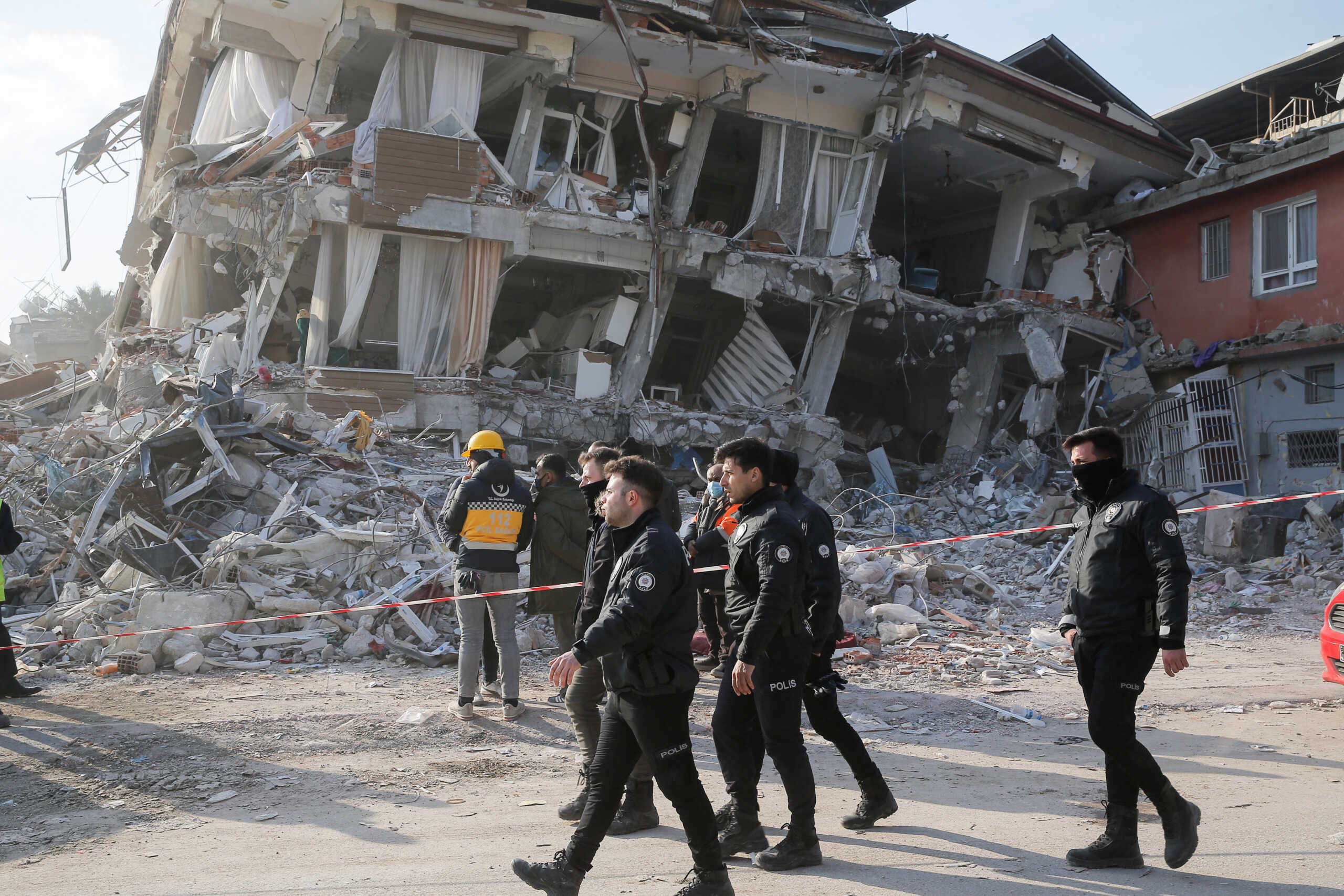 Turkish police officers walk past by a damaged building as they patrol, in the aftermath of a deadly earthquake in Hatay, Turkey February 11, 2023. REUTERS