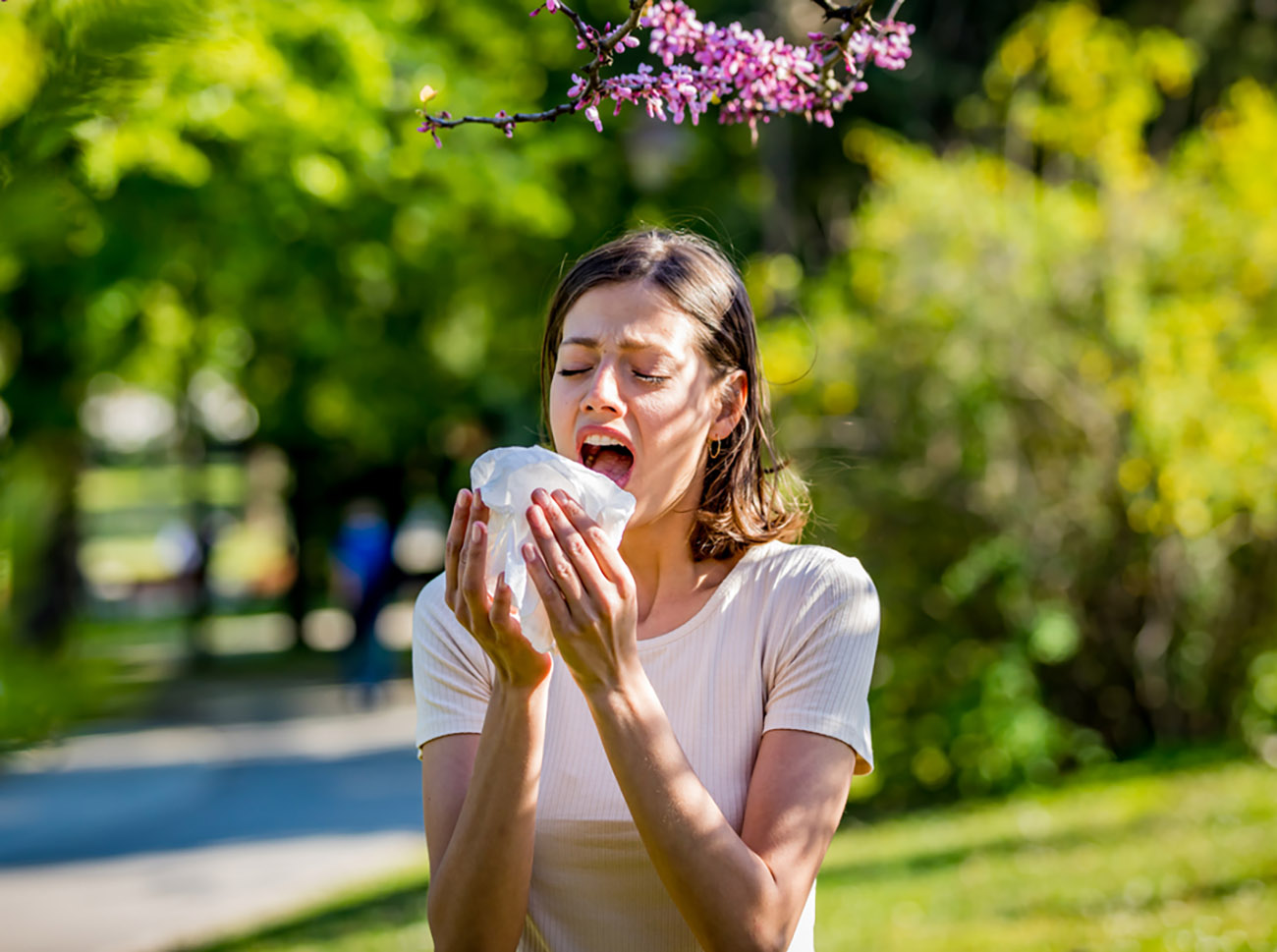 Woman has sneezing. Young woman is having flu and she is sneezing. Sickness, seasonal virus problem concept. Woman being sick having flu sneezing.