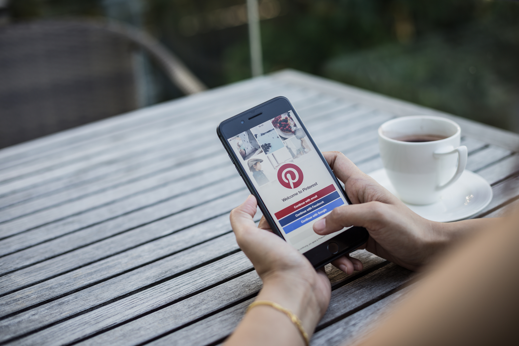 Chonburi, Thailand - January 01, 2018 : Apple iPhone 8 Plus showing Pinterest application on mobile. It was held by woman hand in cafe shop.