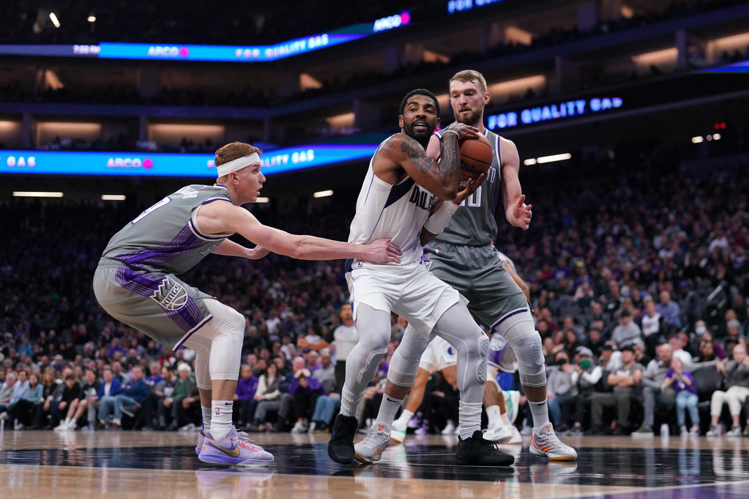 Feb 10, 2023; Sacramento, California, USA; Dallas Mavericks guard Kyrie Irving (2) holds onto a rebound between Sacramento Kings guard Kevin Huerter (9) and forward Domantas Sabonis (10) in the second quarter at the Golden 1 Center. Mandatory Credit: Cary Edmondson-USA TODAY Sports