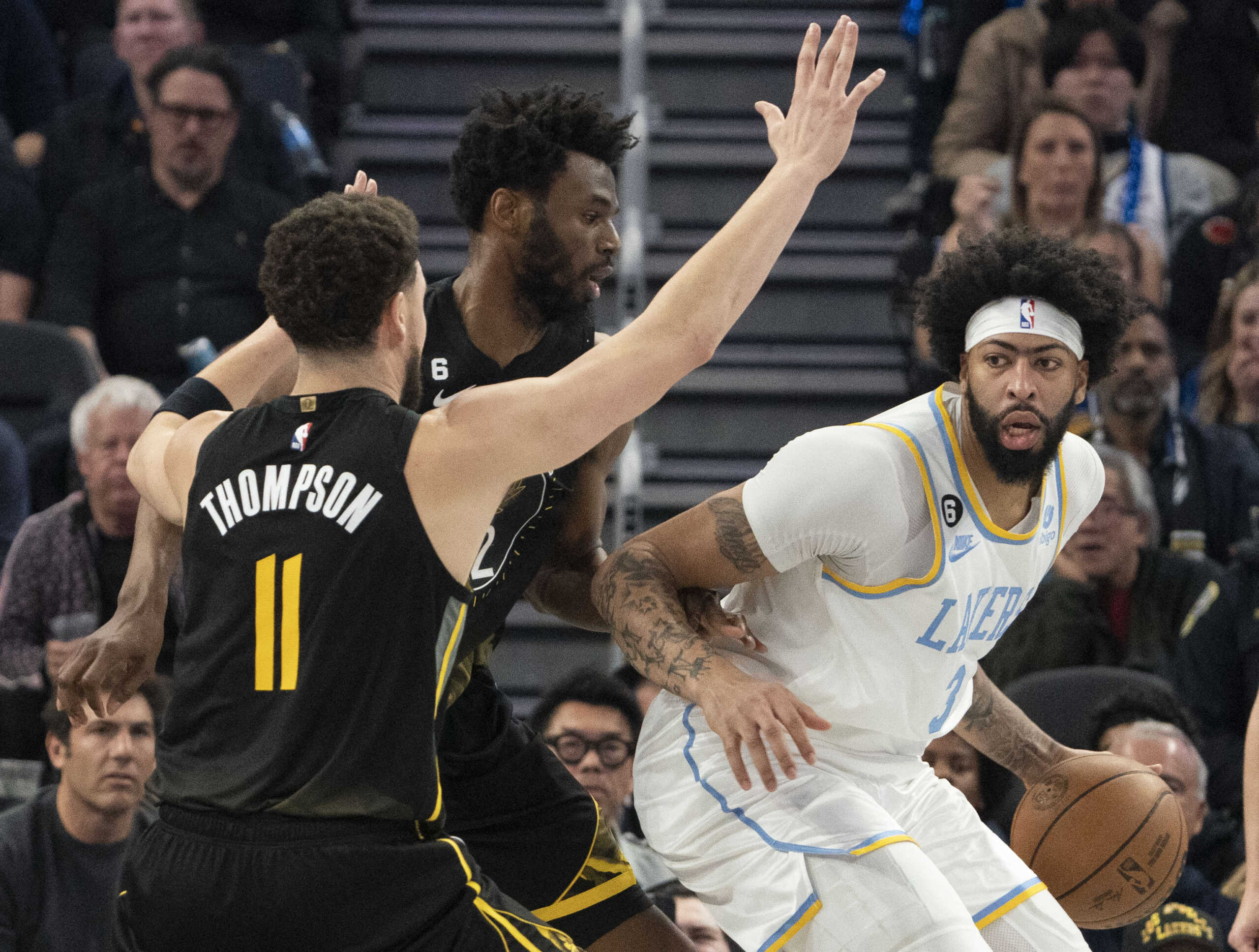 February 11, 2023; San Francisco, California, USA; Los Angeles Lakers forward Anthony Davis (3) dribbles the basketball against Golden State Warriors guard Klay Thompson (11) and forward Andrew Wiggins (22) during the second quarter at Chase Center. Mandatory Credit: Kyle Terada-USA TODAY Sports
