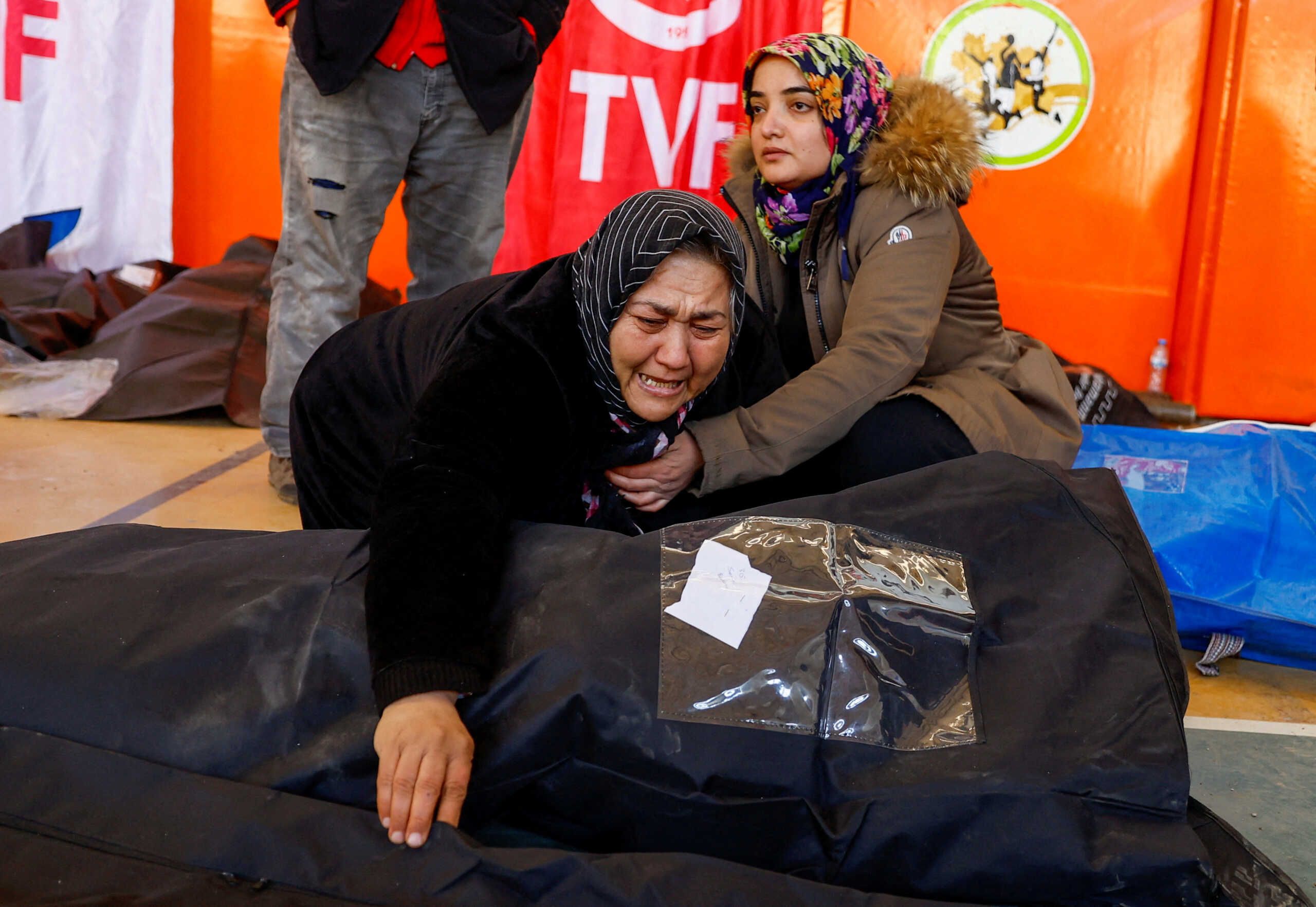 Women react next to the body of a relative, kept at a stadium, in the aftermath of a deadly earthquake in Kahramanmaras, Turkey, February 8, 2023. REUTERS