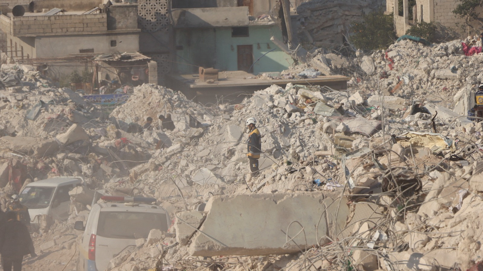 A White Helmet volunteer stands among rubble,  in the aftermath of a deadly earthquake, in Harem, Idlib, Syria February 10, 2023. White Helmets