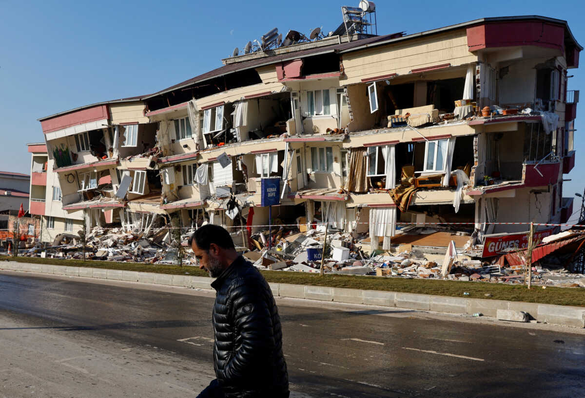 A man walks past a damaged building in the aftermath of a deadly earthquake in Kahramanmaras, Turkey February 13, 2023. REUTERS