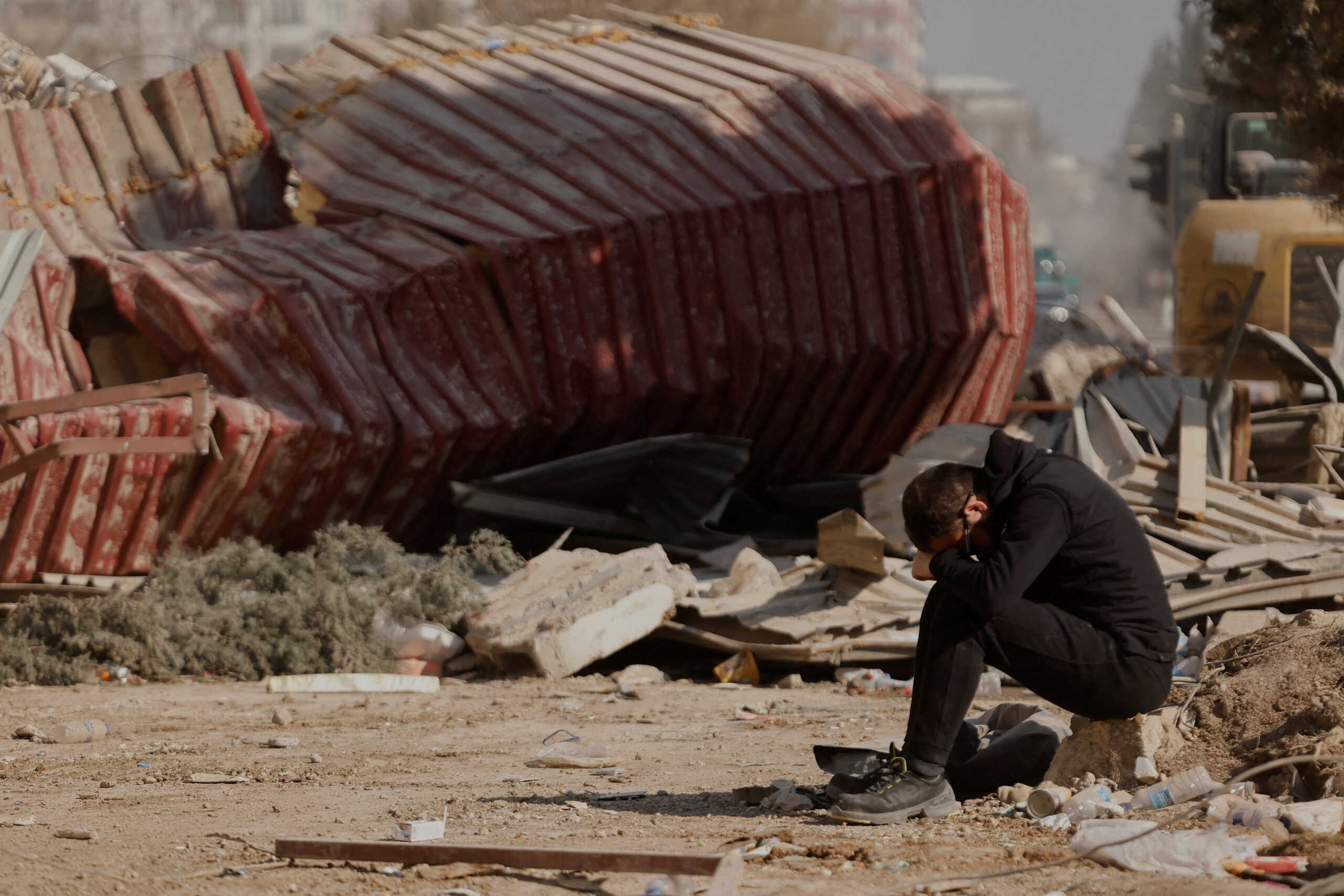 A man reacts as people search the rubble of collapsed apartment blocks for personal belongings, in the aftermath of a deadly earthquake, in Kahramanmaras, Turkey, February 18, 2023. REUTERS