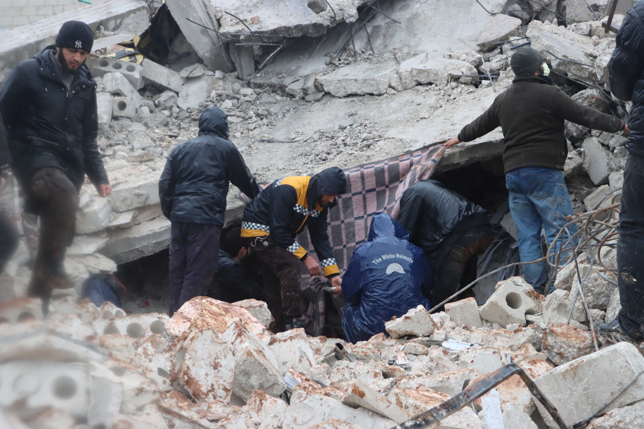 Rescuers search for survivors under the rubble, following an earthquake, in Al Atarib, Syria February 6, 2023 in this picture obtained from social media. White Helmets