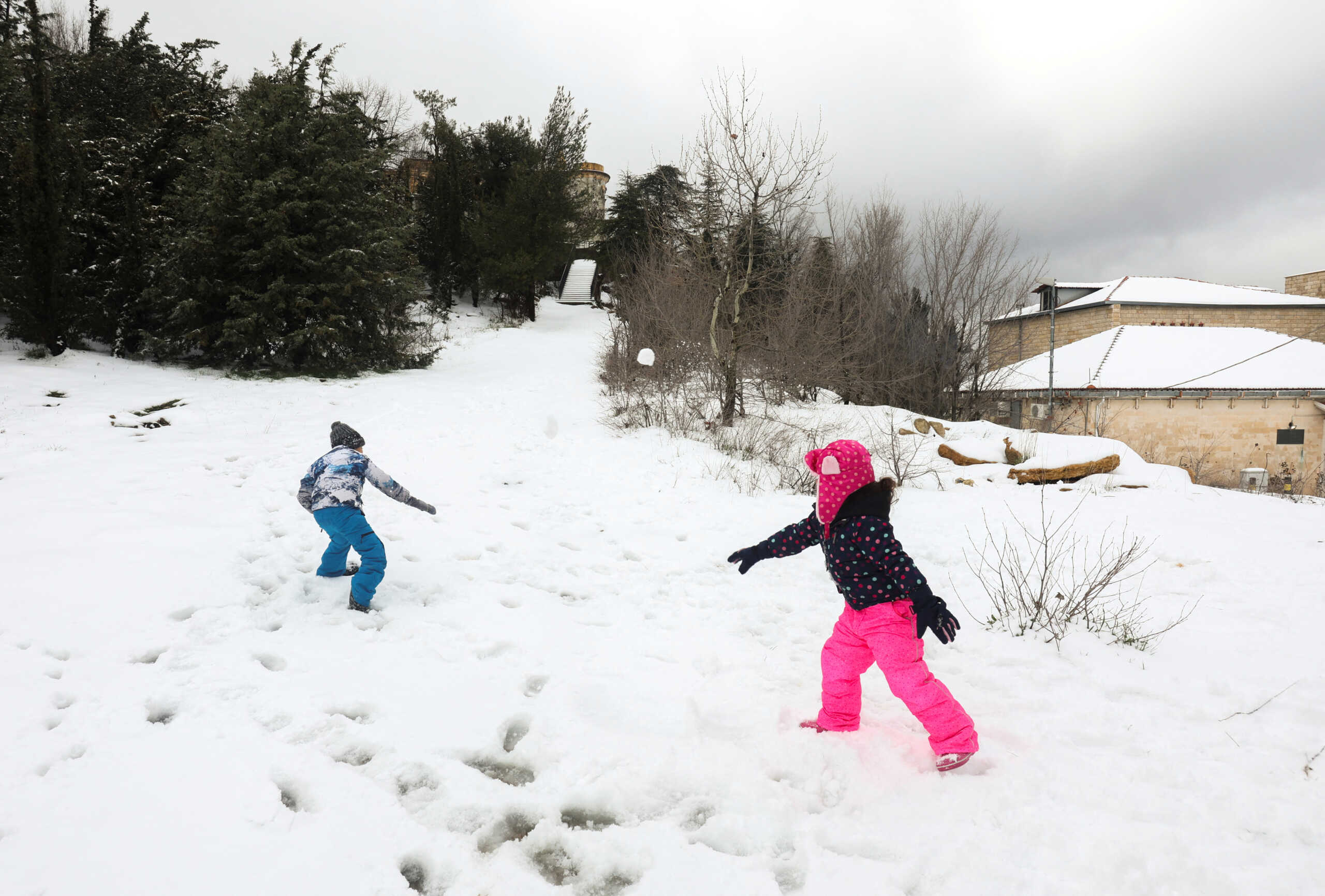 Children play with each other in snow at Sawfar village, Lebanon February 2, 2023. REUTERS