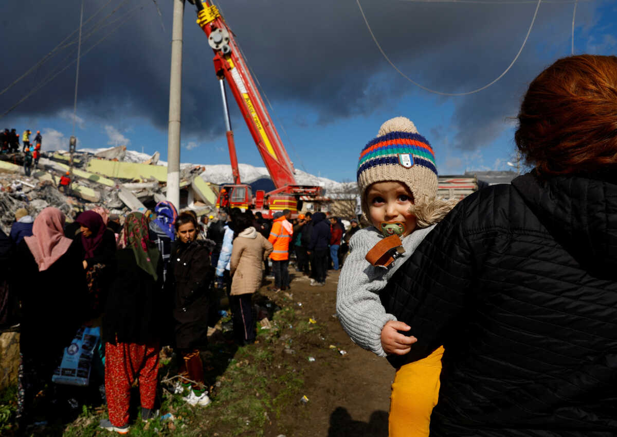 People stand near rubble and damages following an earthquake in Gaziantep, Turkey, February 7, 2023. REUTERS