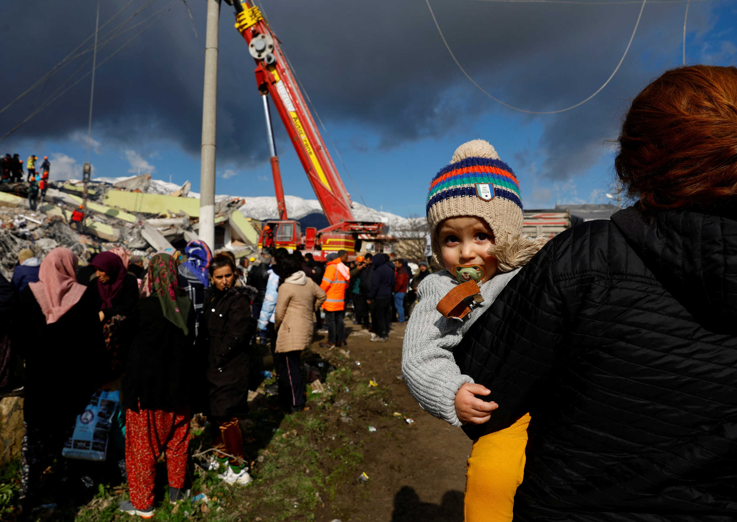People stand near rubble and damages following an earthquake in Gaziantep, Turkey, February 7, 2023. REUTERS