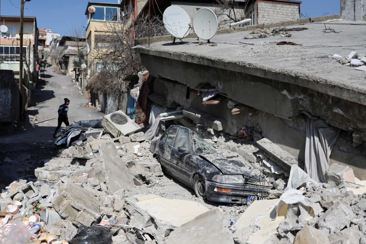 A man walks next to a collapsed house in the aftermath of a deadly earthquake in Kahramanmaras, Turkey February 14, 2023. REUTERS