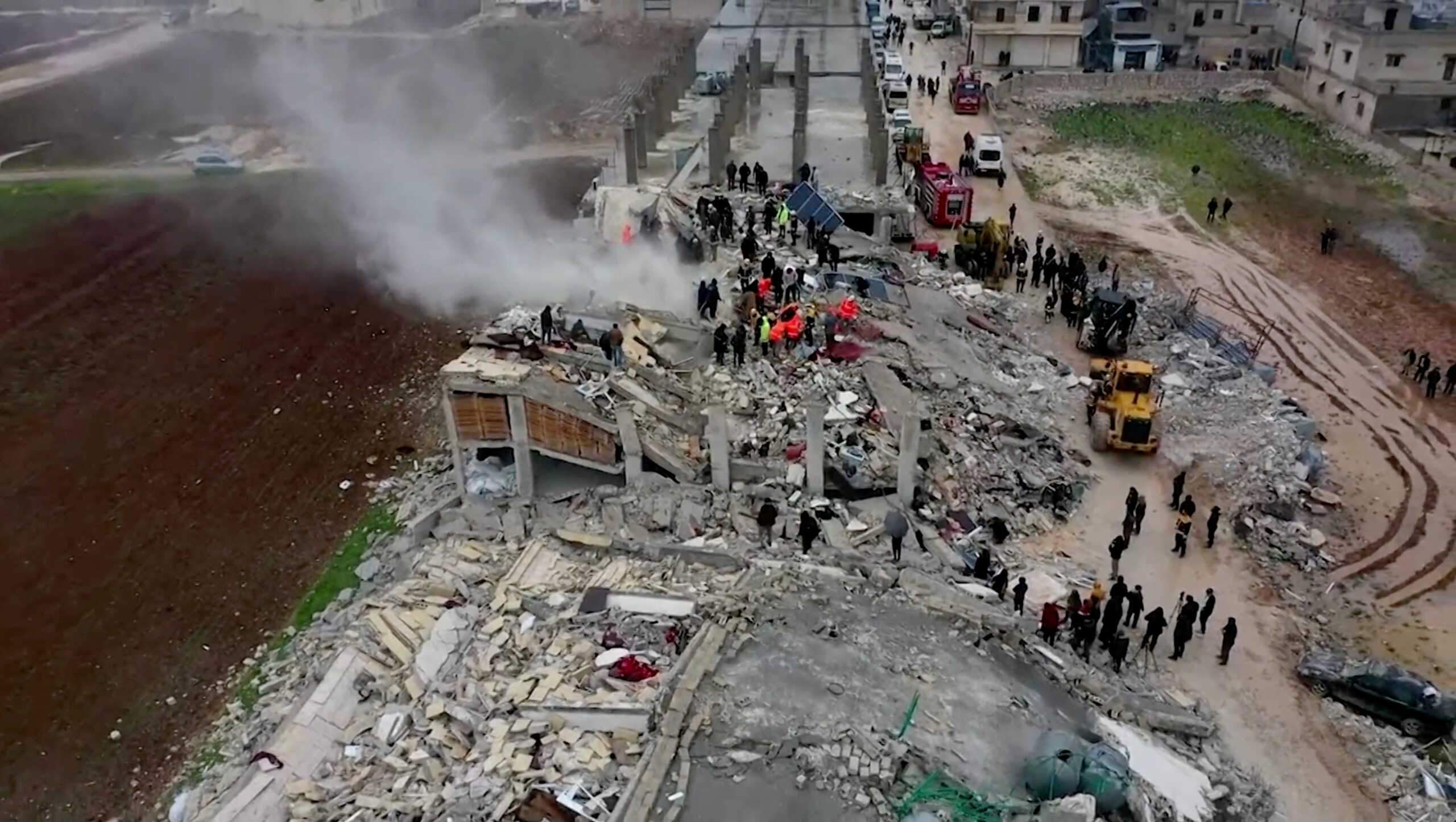 Rescuers search through rubble of collapsed buildings following an earthquake, in the rebel-held town of Sarmada, Syria February 6, 2023 in this still image obtained from a drone footage.  WHITE HELMETS