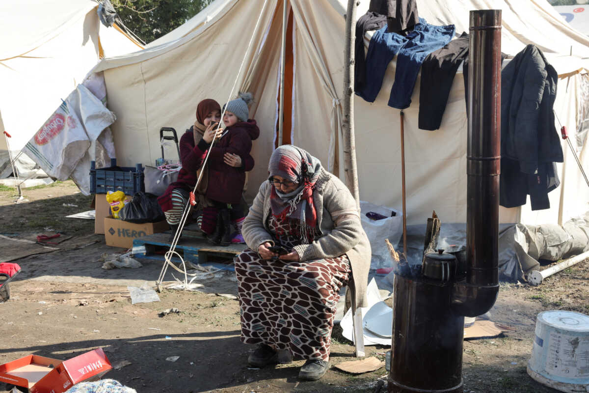 Women sit by a tent as search for survivors continues, in the aftermath of a deadly earthquake in Hatay, Turkey, February 10, 2023. REUTERS