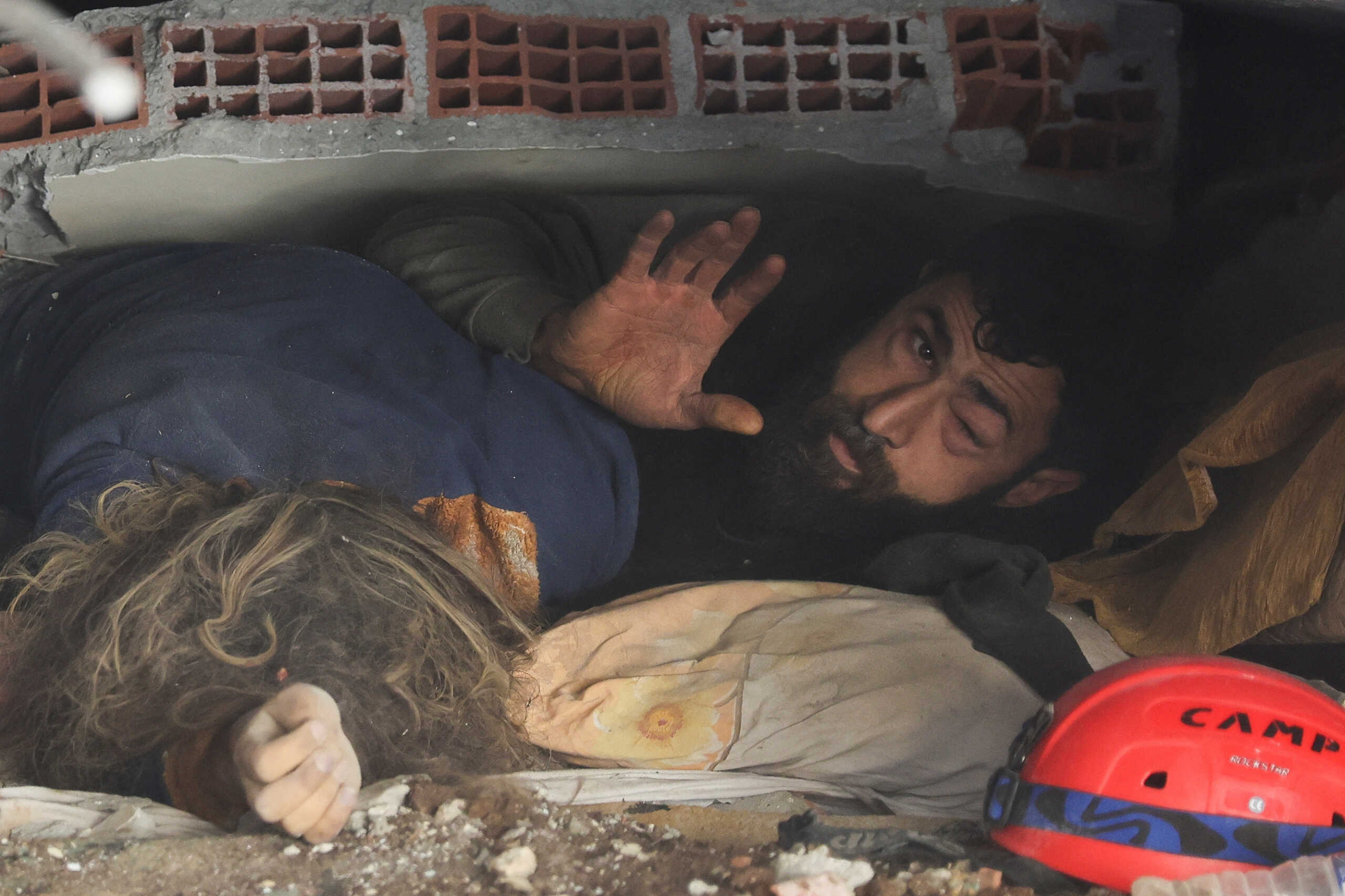 SENSITIVE MATERIAL. THIS IMAGE MAY OFFEND OR DISTURB     Abdulalim Muaini lies under the rubble next to the body of his wife Esra, in the aftermath of a deadly earthquake in Hatay, Turkey, February 8, 2023. REUTERS