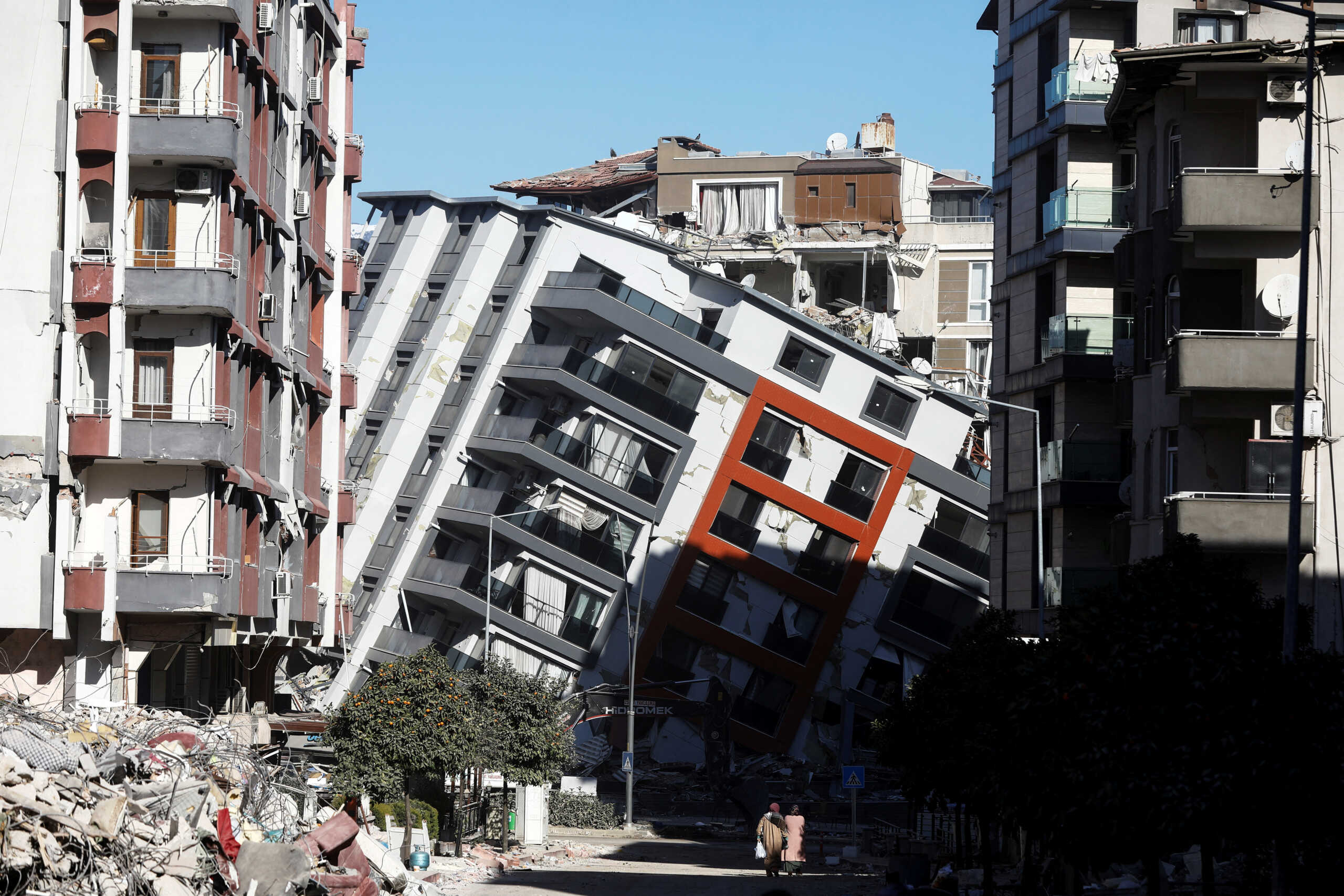 Women walk together in front of a damaged building, in the aftermath of the deadly earthquake, in Antakya, Turkey February 17, 2023. REUTERS
