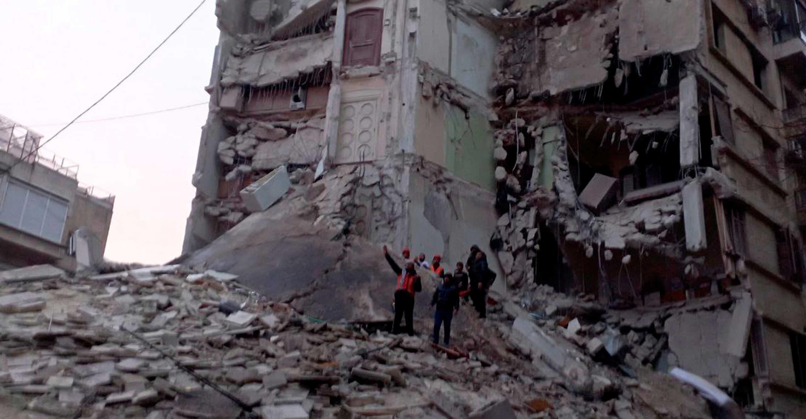 Rescuers search for survivors amid the rubble of a damaged building, following an earthquake, in Aleppo, Syria, in this handout released by SANA on February 6, 2023. SANA