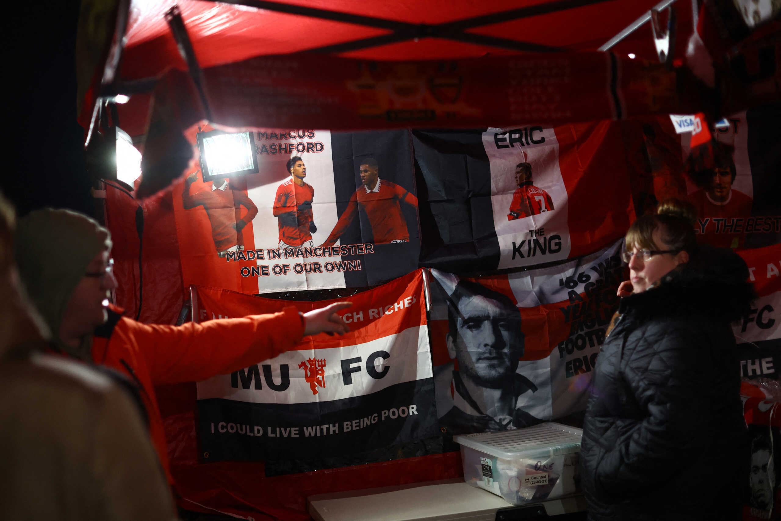 Soccer Football - Europa League - Play-Off Second Leg - Manchester United v FC Barcelona - Old Trafford, Manchester, Britain - February 23, 2023 Manchester United banners for sale outside the stadium before the match REUTERS