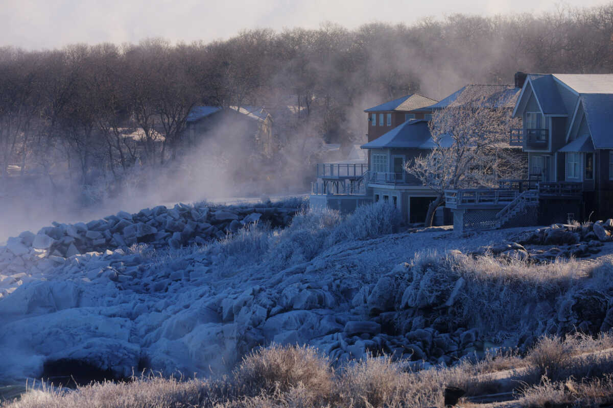 Sea smoke rolls off the ocean and frozen spray covers rocks and homes as an Arctic Front brings bitterly cold weather in Gloucester, Massachusetts, U.S., February 4, 2023.     REUTERS