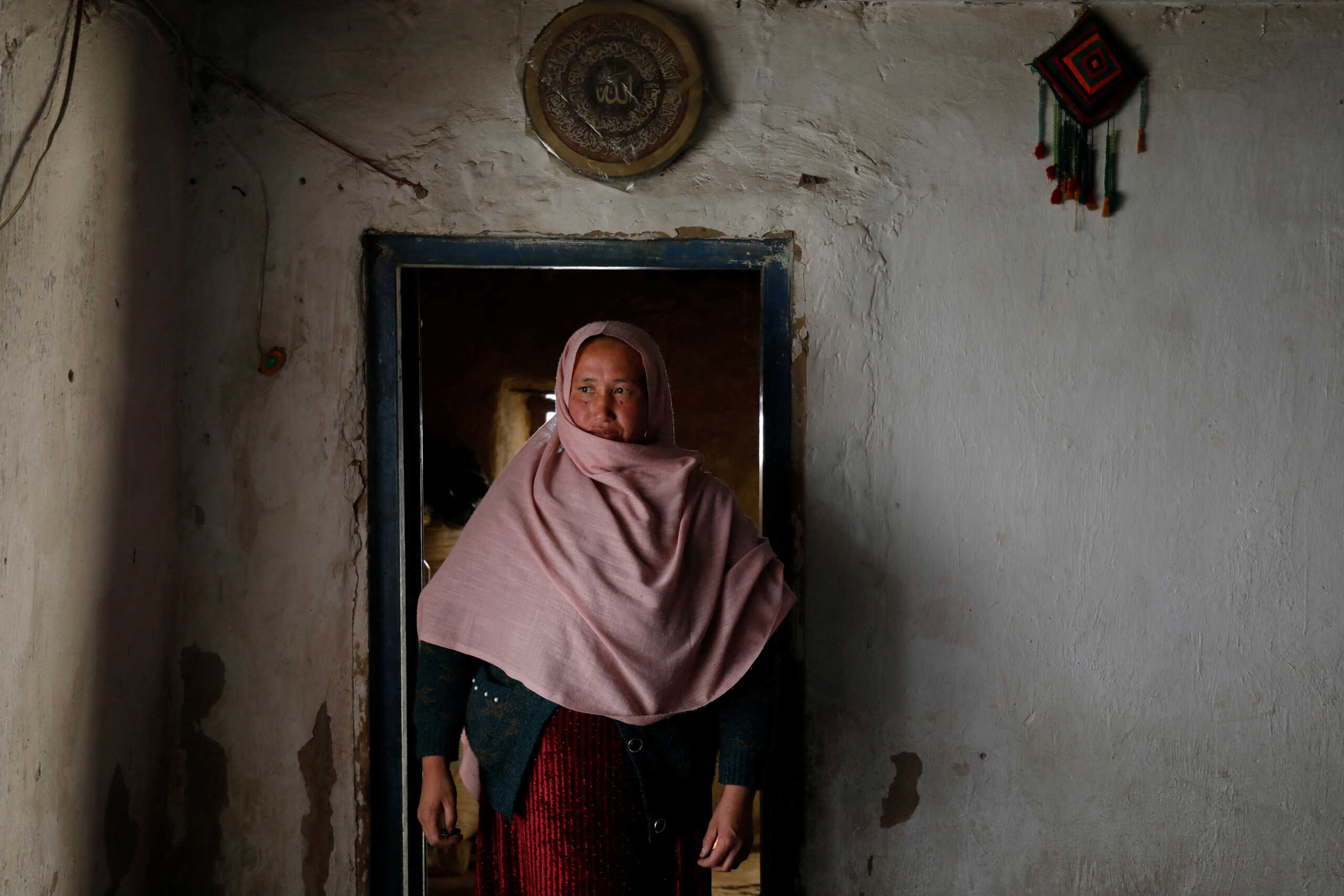 Aziza Rahimi, 35, who lost her son at birth, walks inside her house in Foladi Valley in Bamiyan, Afghanistan, March 2, 2023. Rahimi stumbled while bleeding for two hours to her in-laws' house after her husband was unable to find a car or ambulance to take them to hospital, she gave birth but the baby died shortly after. "It was too hard for me when I lost my baby, as a mother I nurtured the baby in my womb for 9 months but then I lost him, it is too painful," she said.          REUTERS