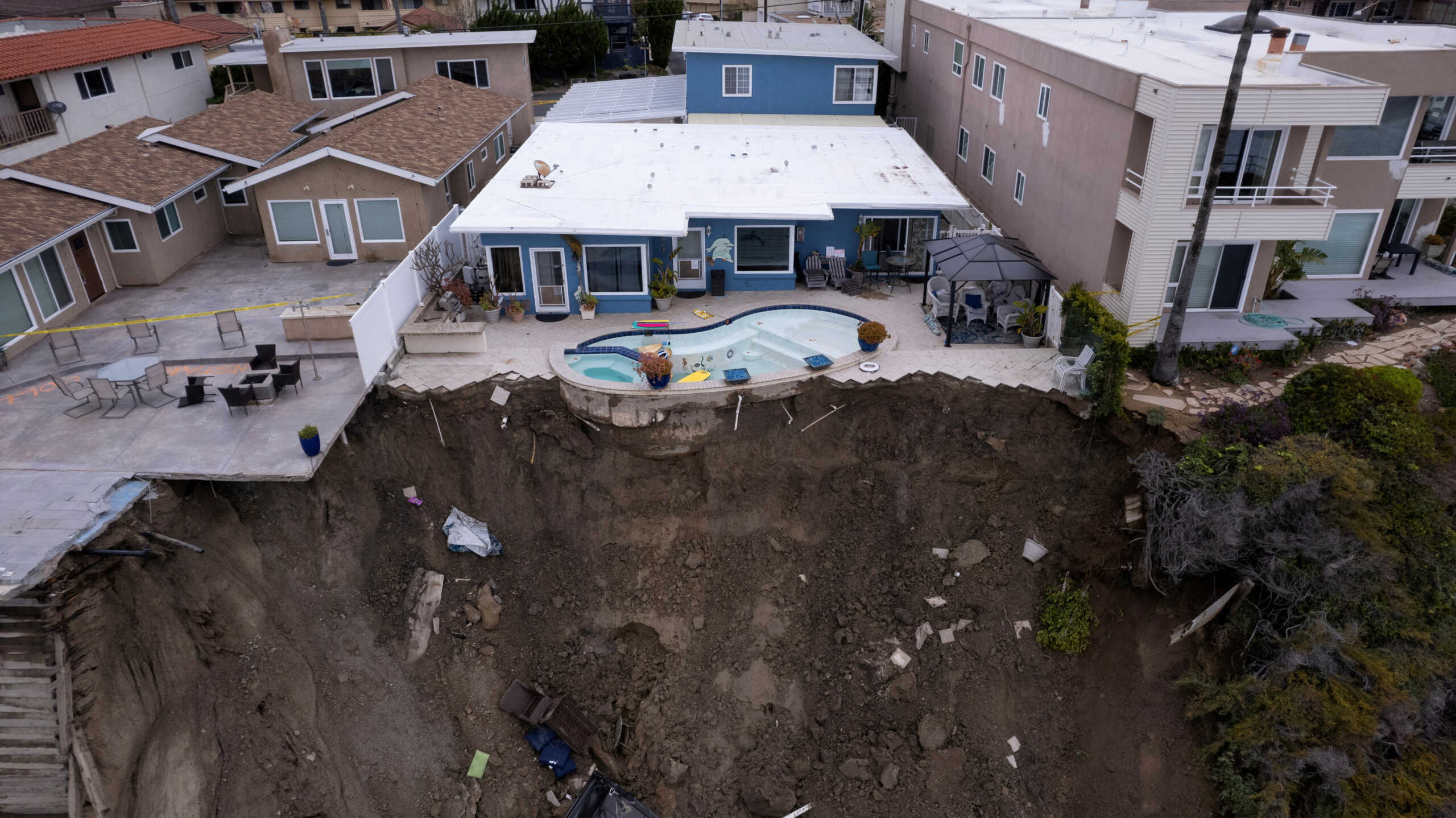 A backyard pool is left hanging on a cliffside after torrential rain brought havoc on the beachfront town of San Clemente, California, U.S. March 16, 2023. REUTERS